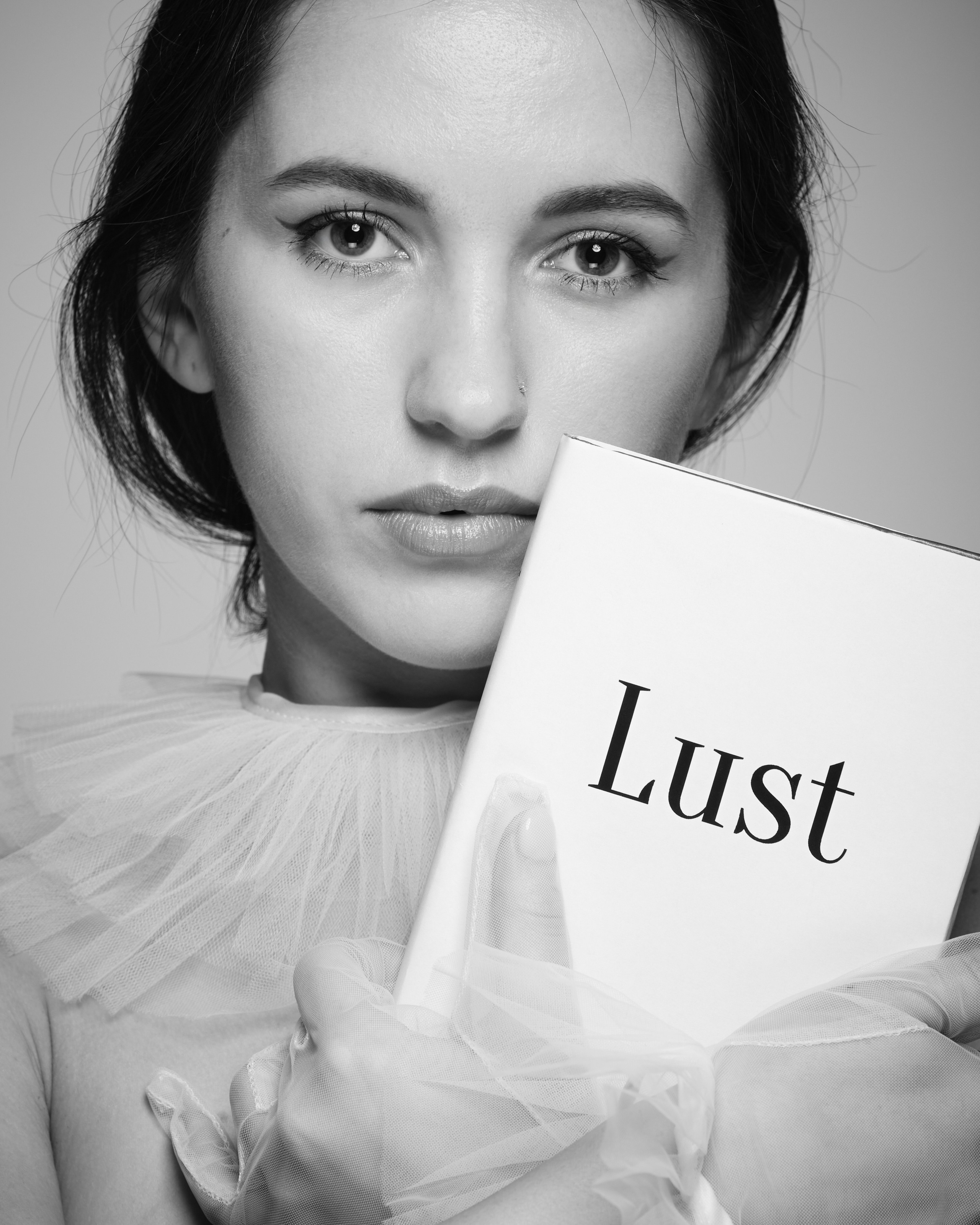 Творческий черно-белый портрет девушки с элементами провокации и выразительным взглядом | Художественная студийная фотосессия для создания эмоционального и концептуального образа