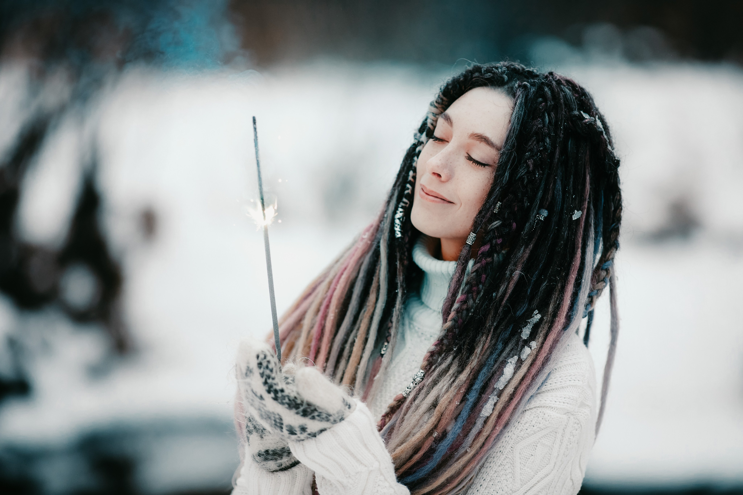 Зимний портрет девушки с дредами и горящим бенгальским огнём в руках