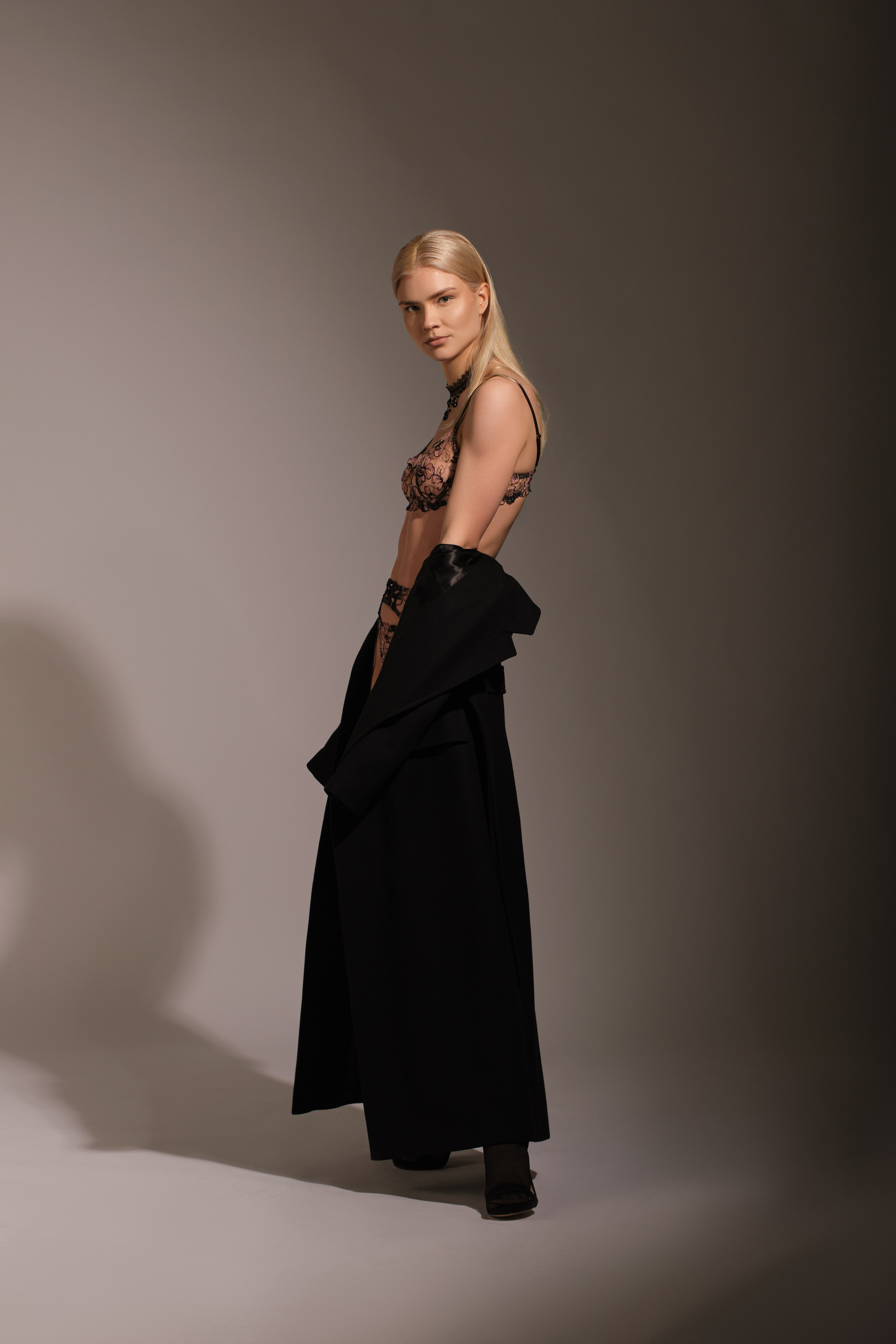 Творческий и эмоциональный портрет: элегантная блондинка в кружевном белье и пальто, художественная студийная съемка для модельного портфолио, фотограф для fashion-съемок.