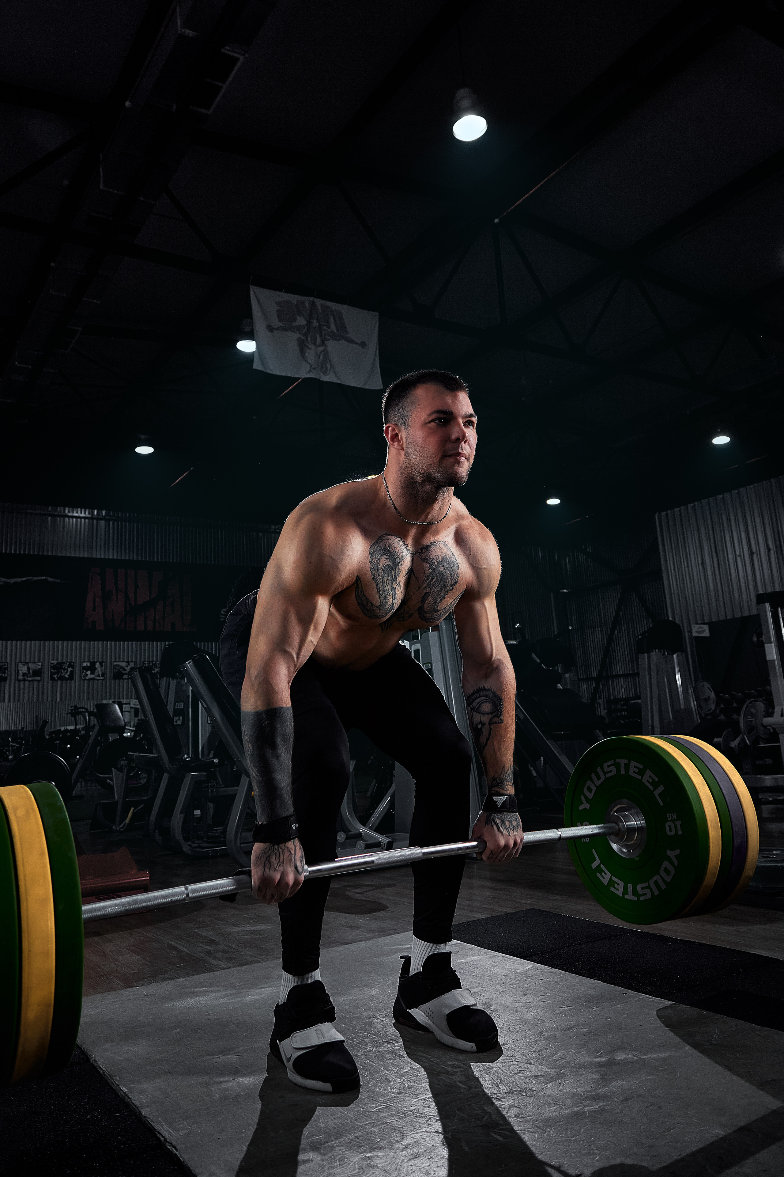 Профессиональная спортивная мужская фитнес фотосессия спортсмена тренера со штангой в тренажерном зале в Москве.