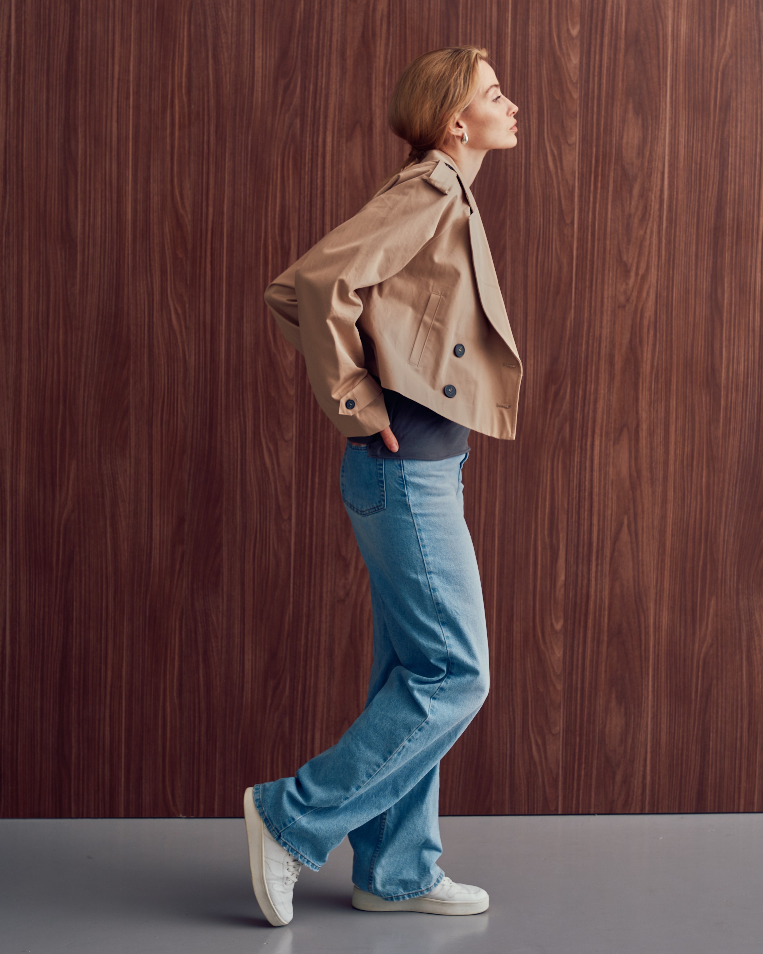 Девушка в коротком тренче и джинсах