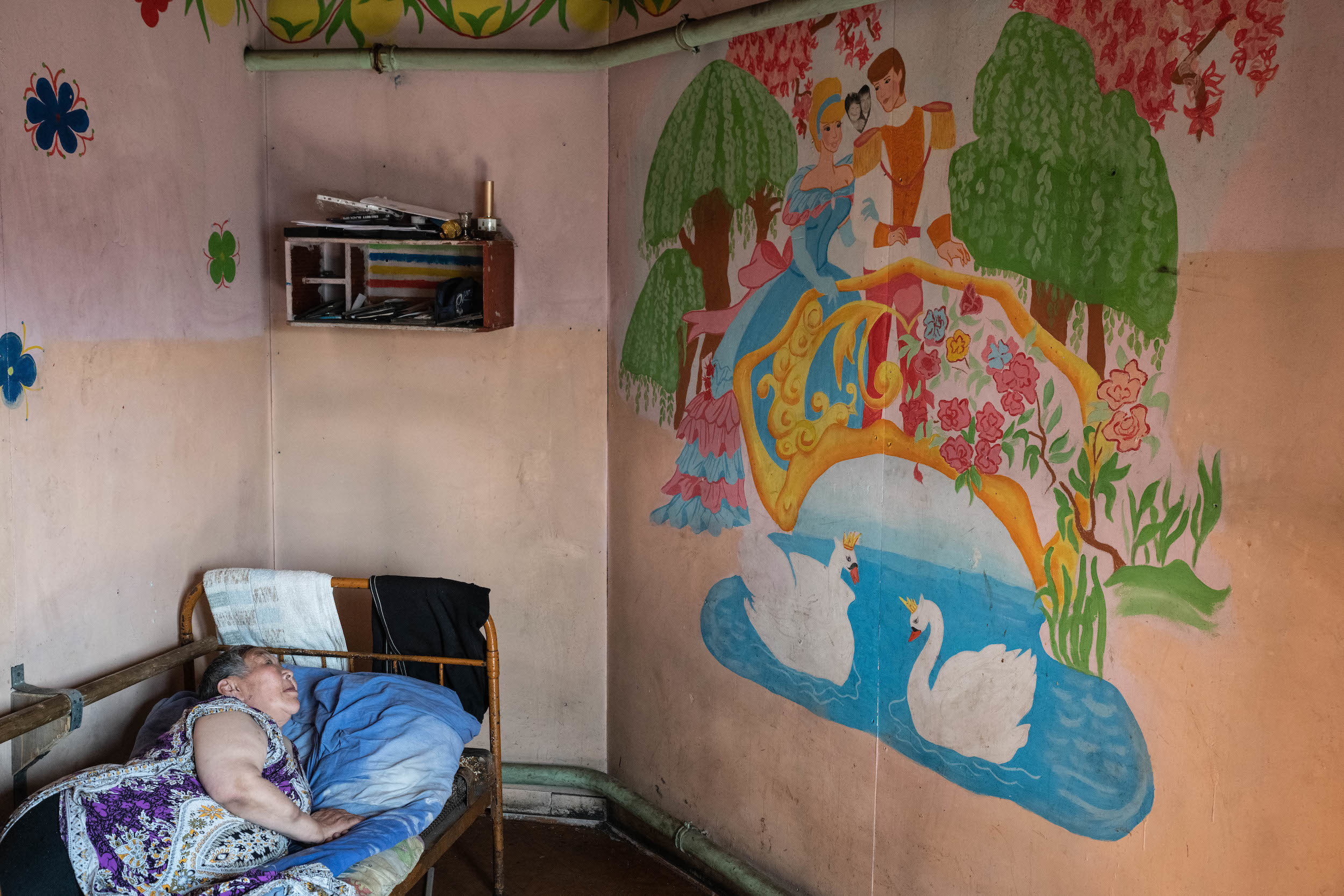 Женщина в Энурмино глядит на фотографию, где она запечатлена вместе с мужем - прямо между принцем и принцессой