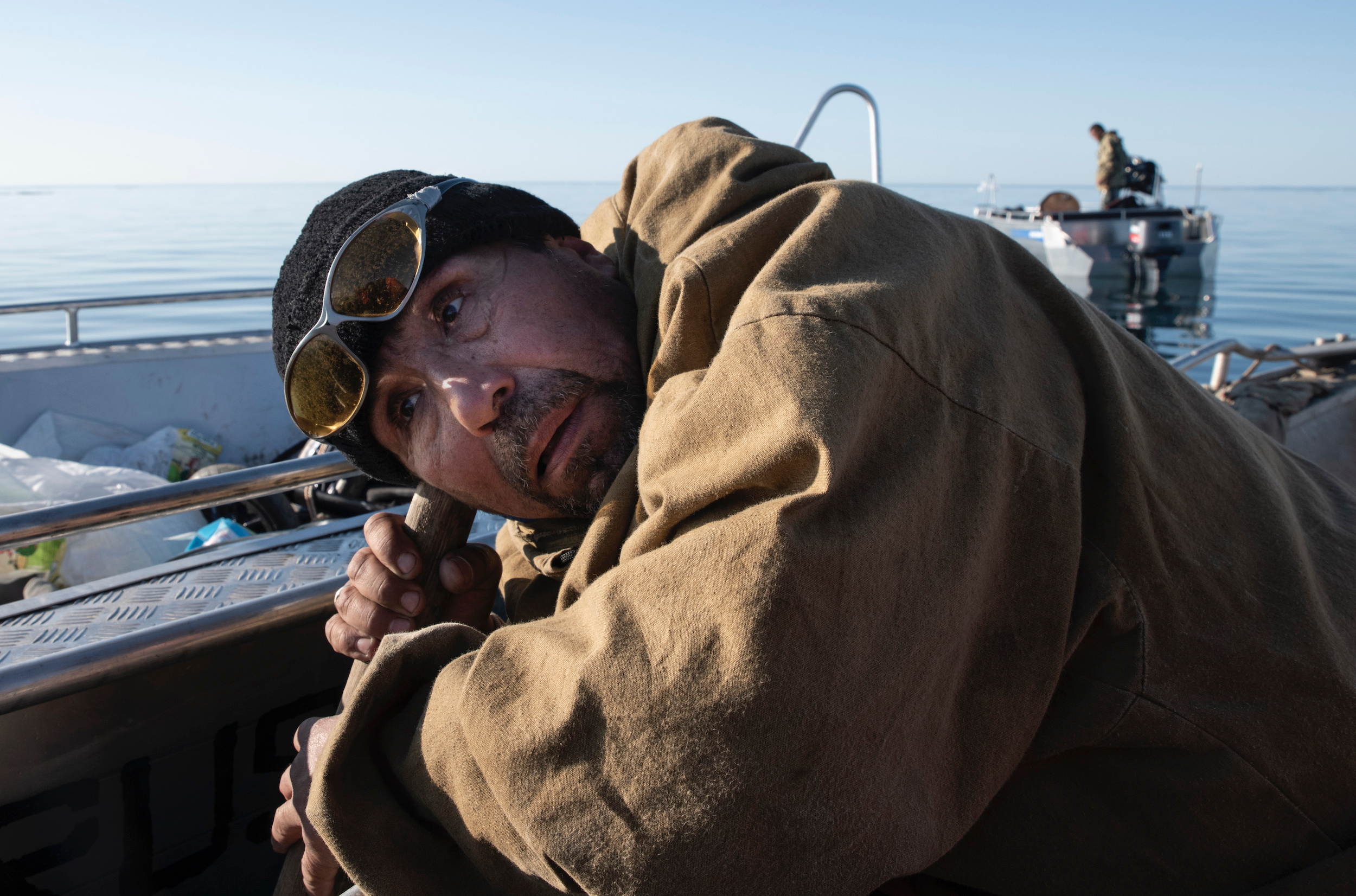 Владимир Эйнеучейвун, глава общины морских зверобоев, приложил ухо к веслу и слушает моржей и нерп в океане