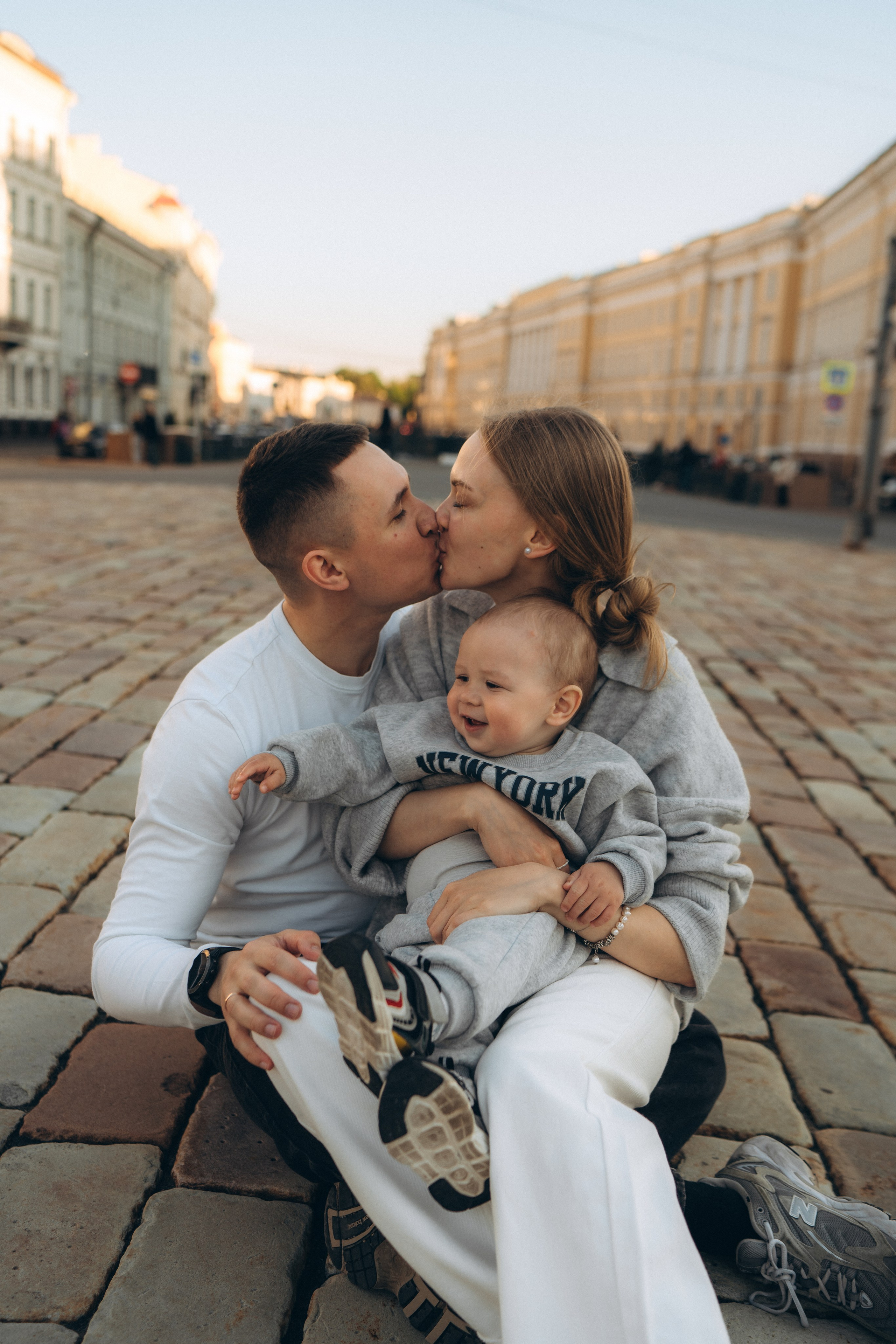 Родители с ребёнком во время семейной фотосессии на улице Санкт-Петербурга