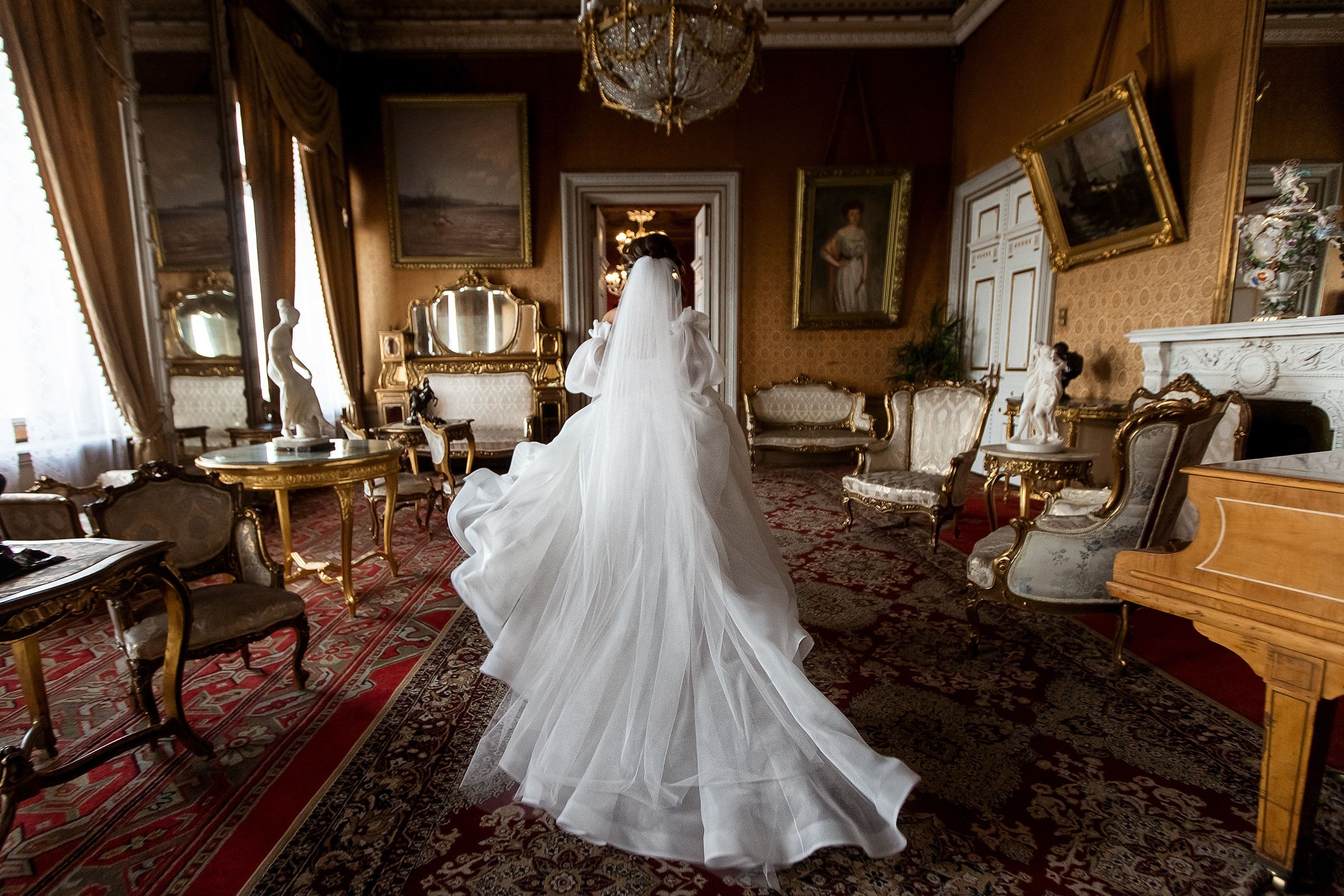 Невеста в красивом платье бежит по комнате в Дворце князя Владимира
