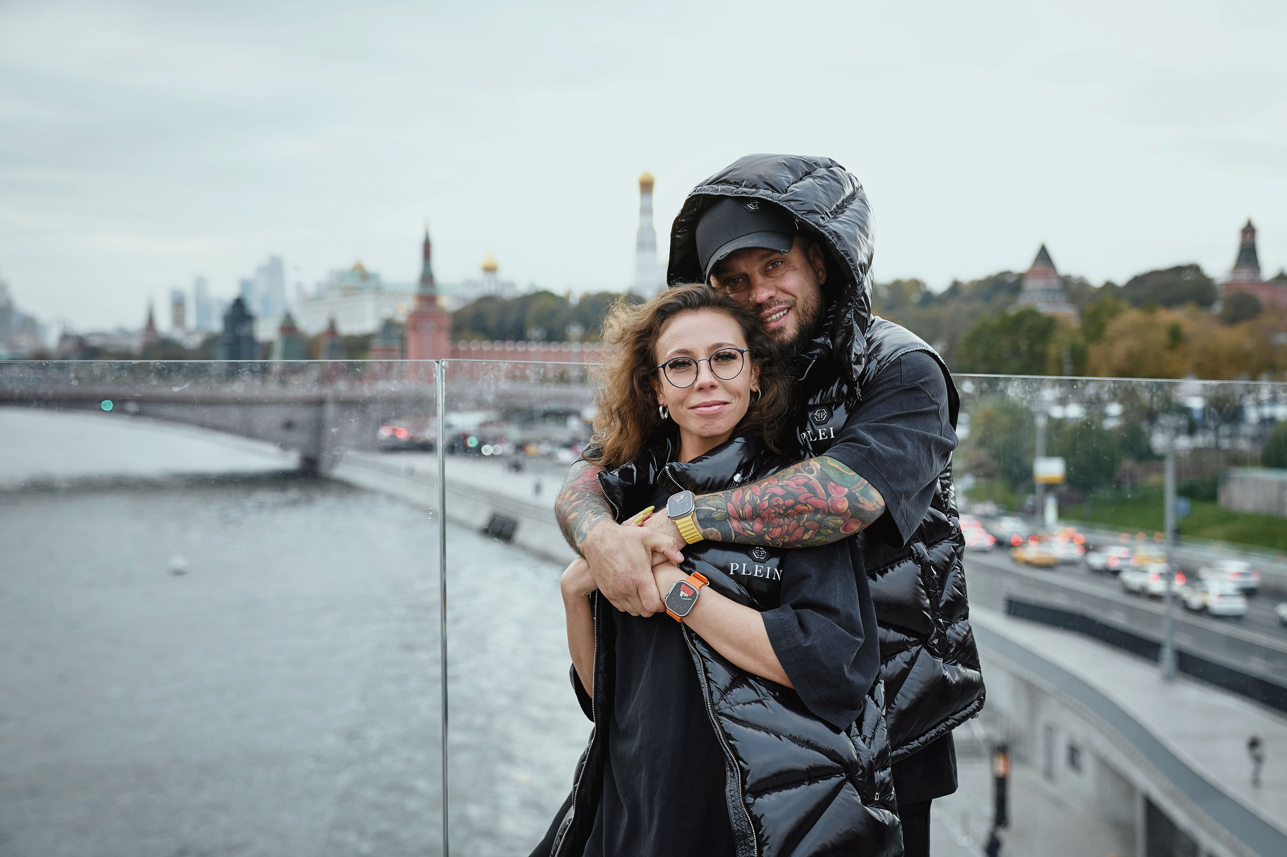 мужчина и женщина обнимаются на парящем мосту в парке Зарядье с видом на Спасскую башню