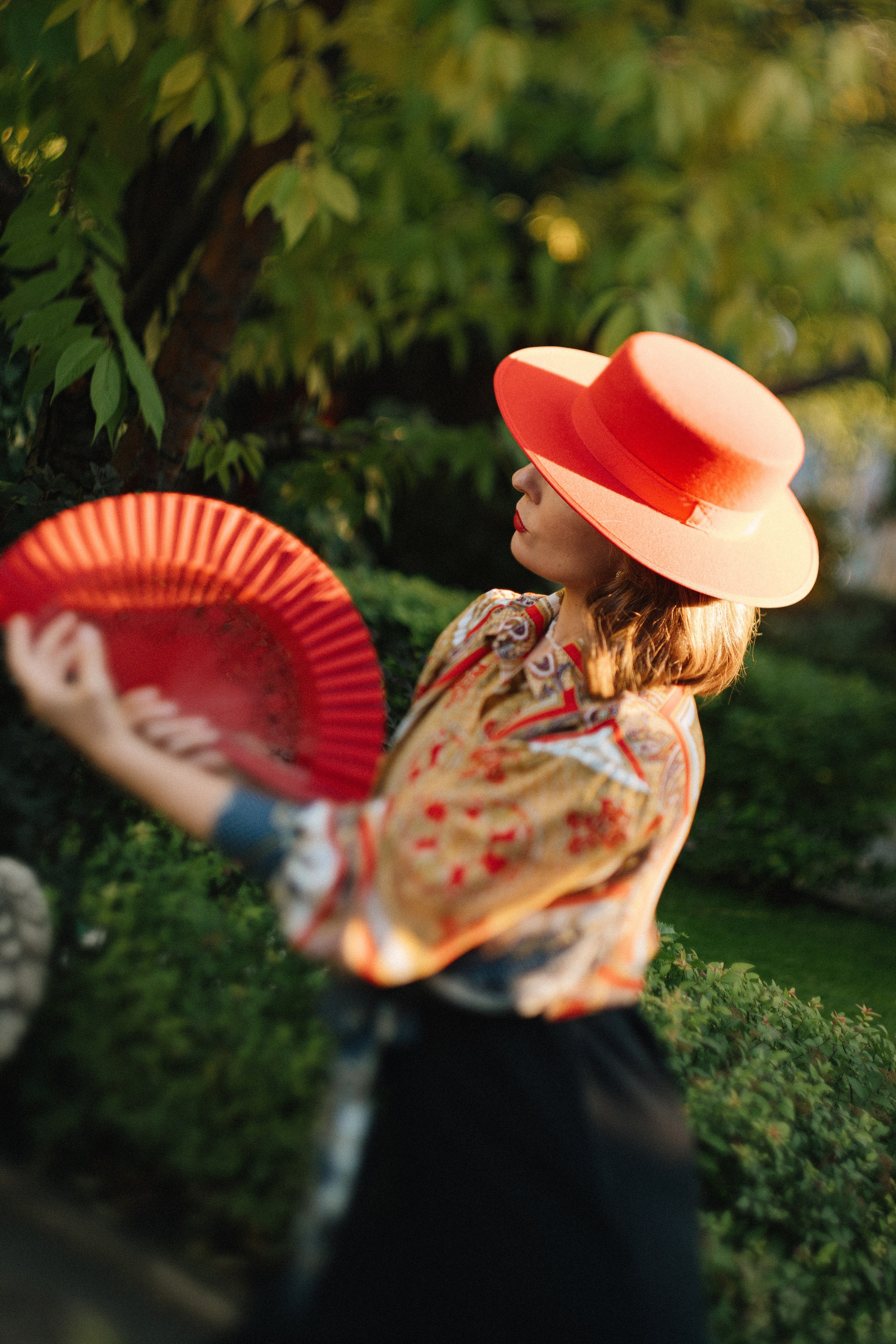 Танцовщица фламенко в профиль с красным веером и в шляпе