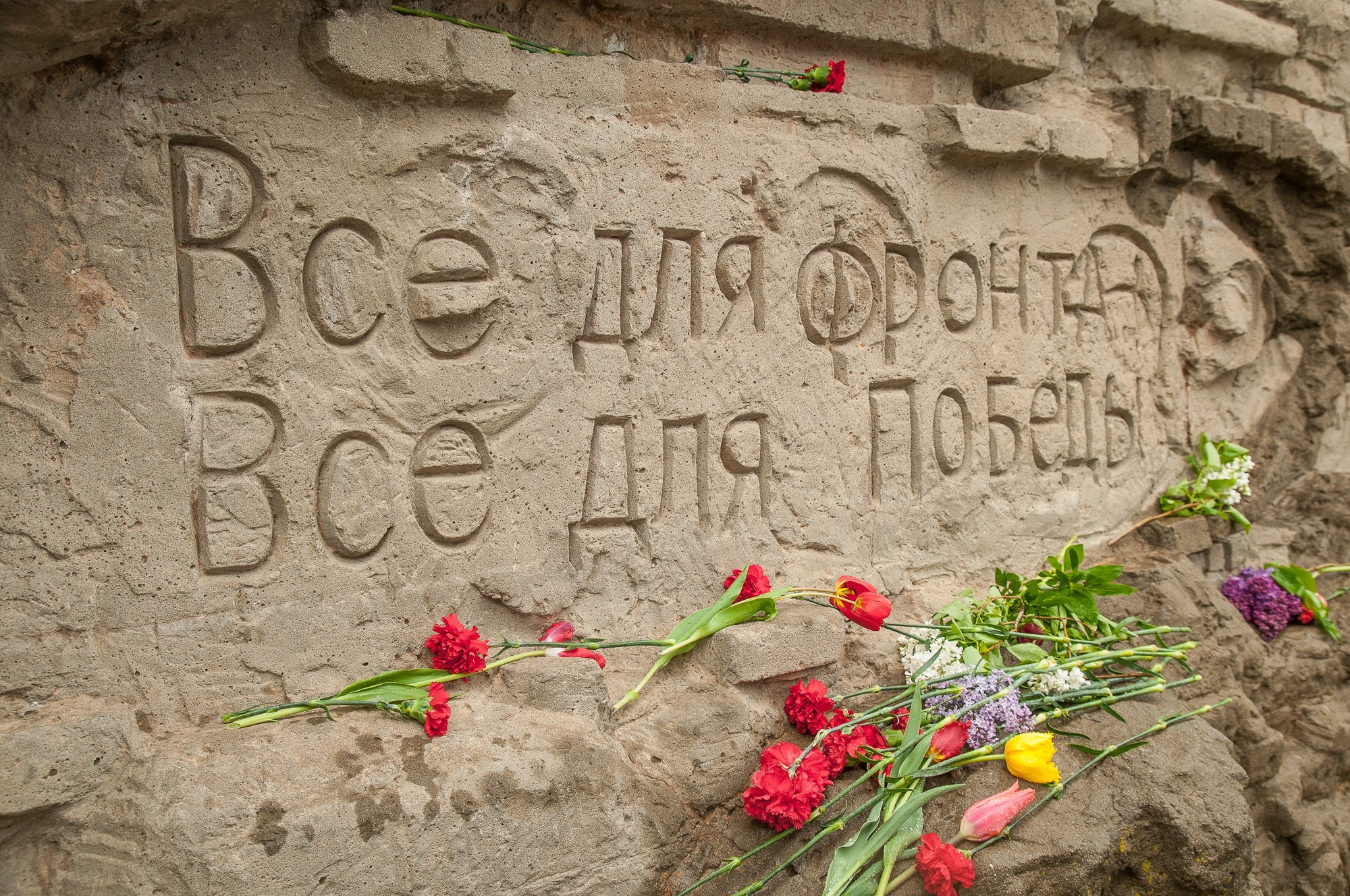 Надпись "Всё для фронта, всё для победы", написанная на бетонной стене