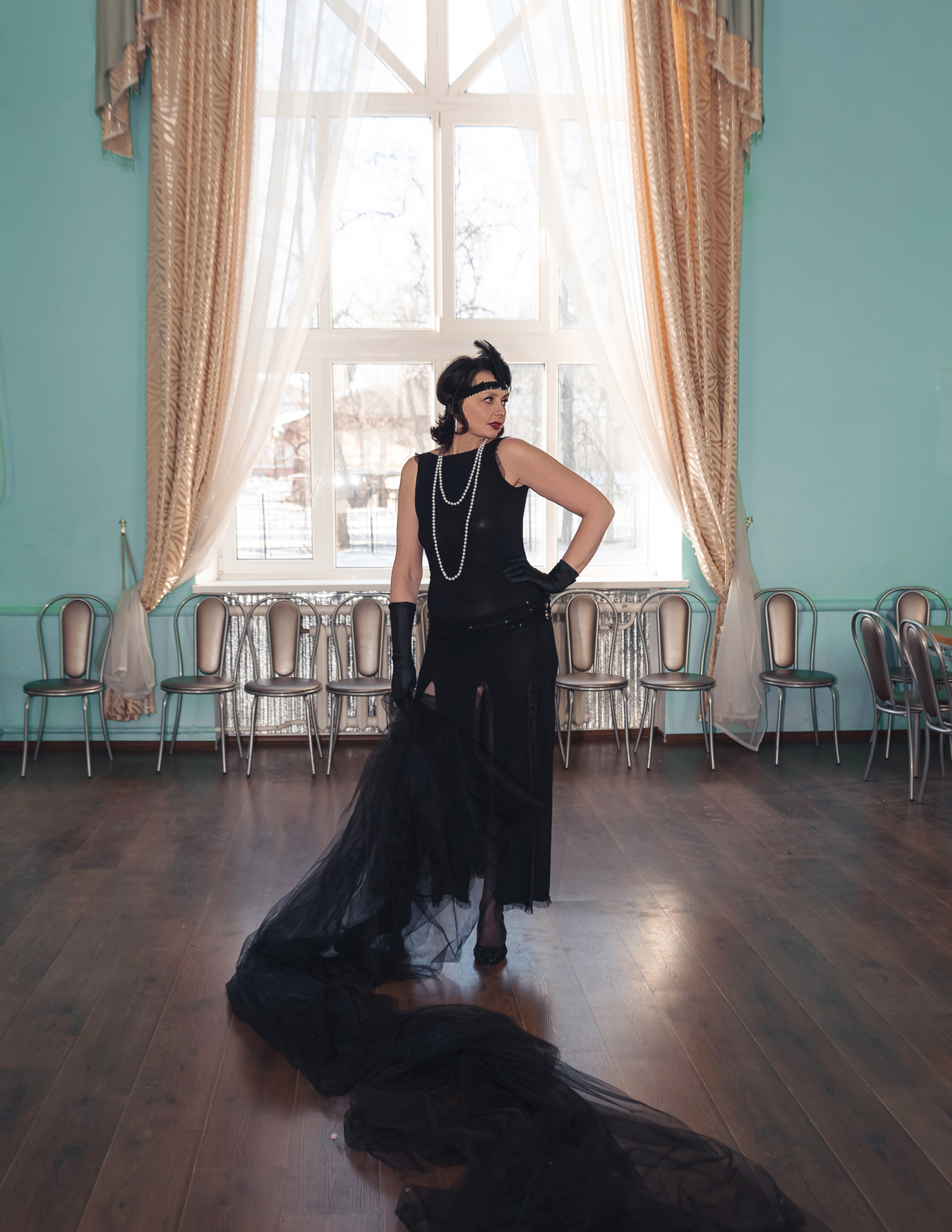 Девушка в стиле ретро, винтаж, Гэтсби с тканью около окна.