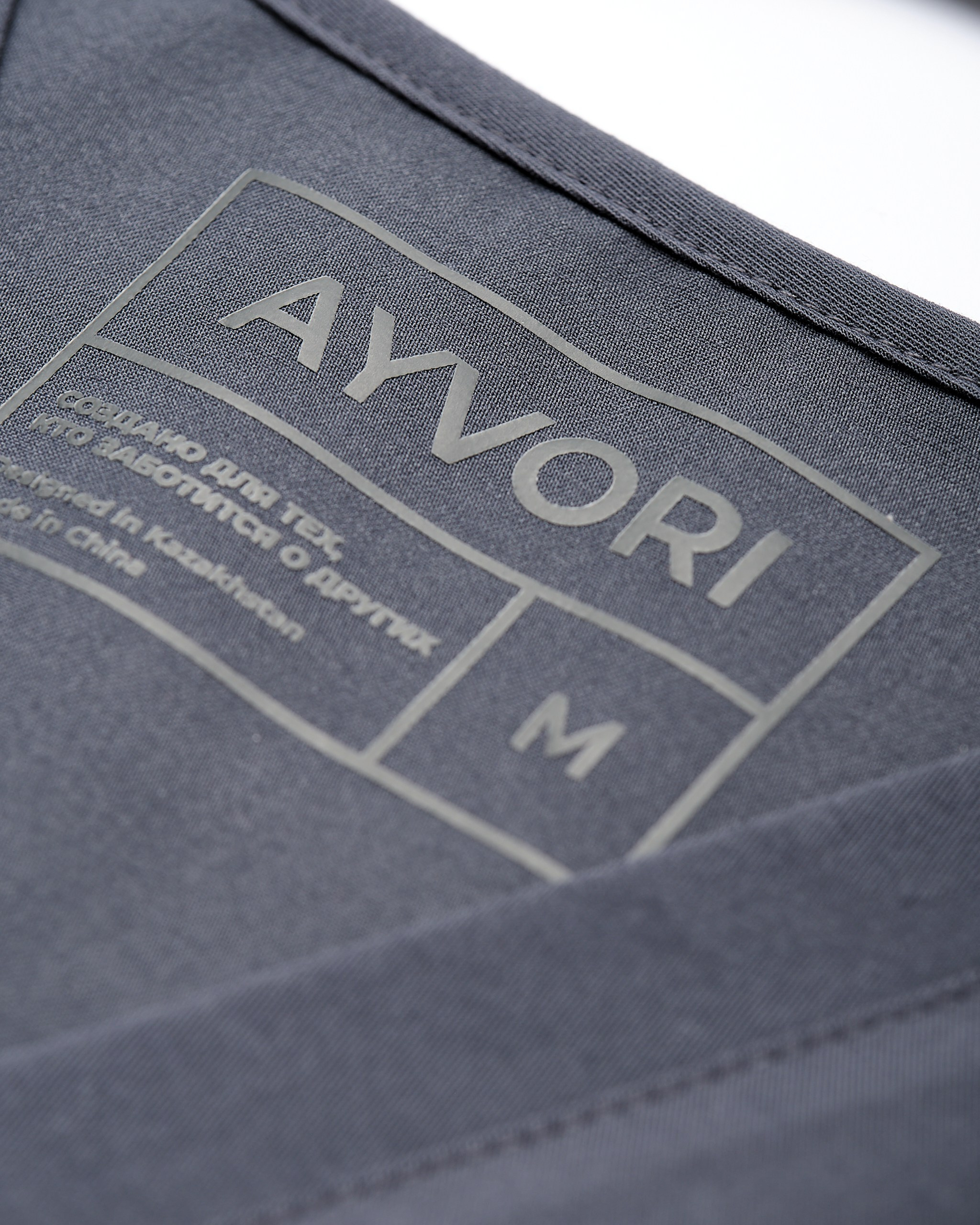 Бирка с логотипом AYVORI на ткани — предметная съёмка медицинской одежды для передачи брендинга и качества