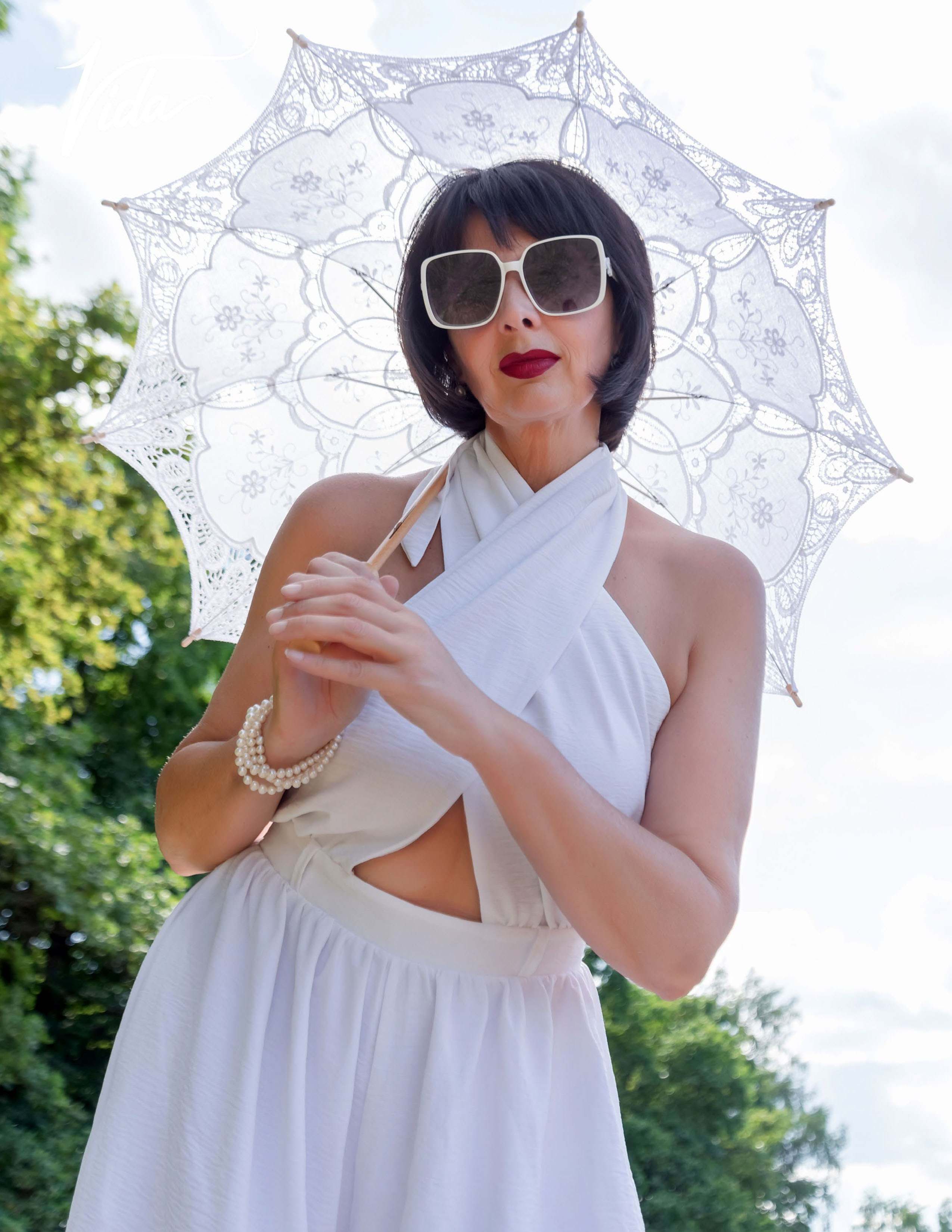 На фото отрывной лист журнала и девушка в белом комбинезоне с летним зонтиком.