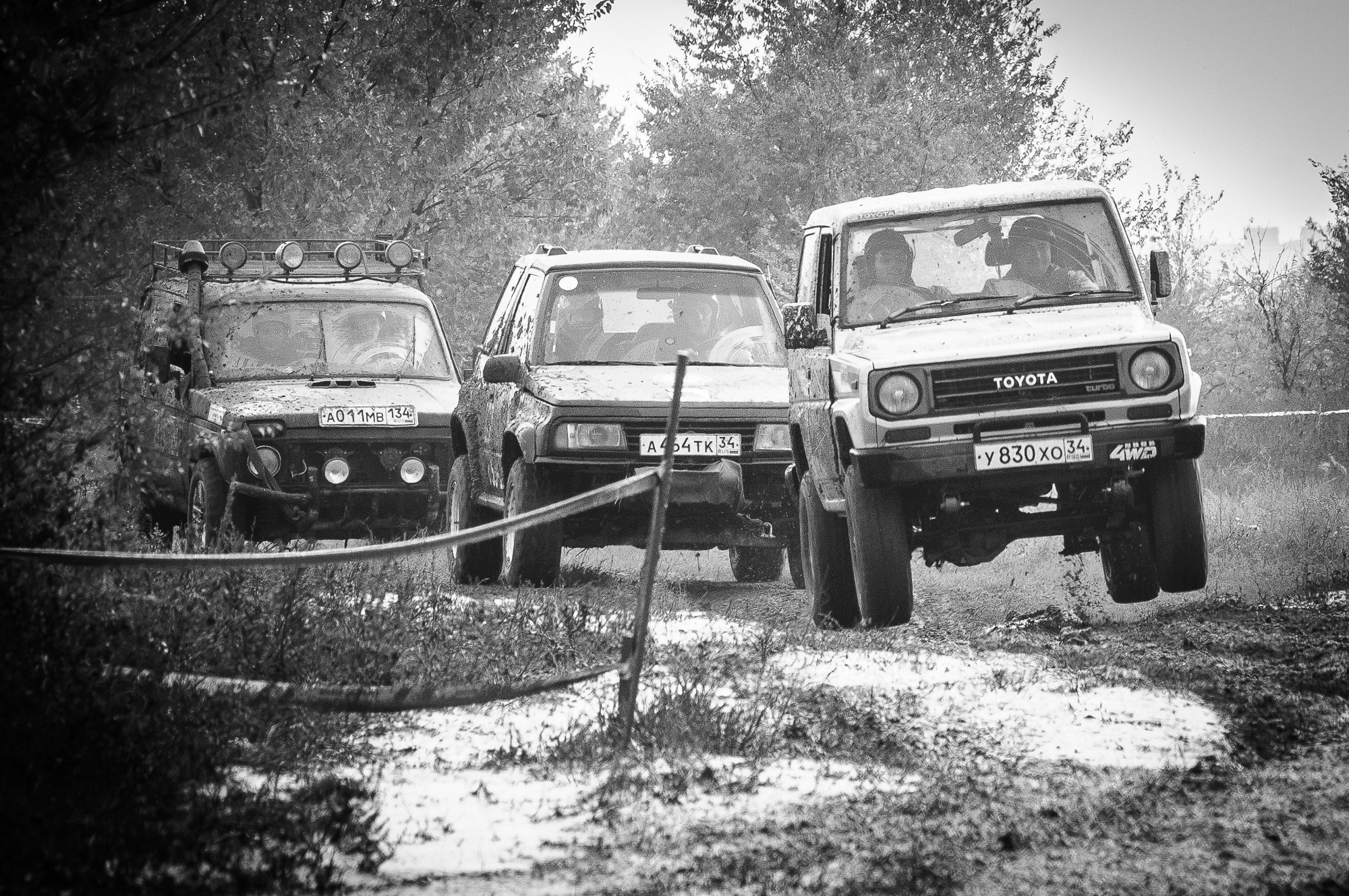 Трофи-рейд, три автомобиля едут по грязи