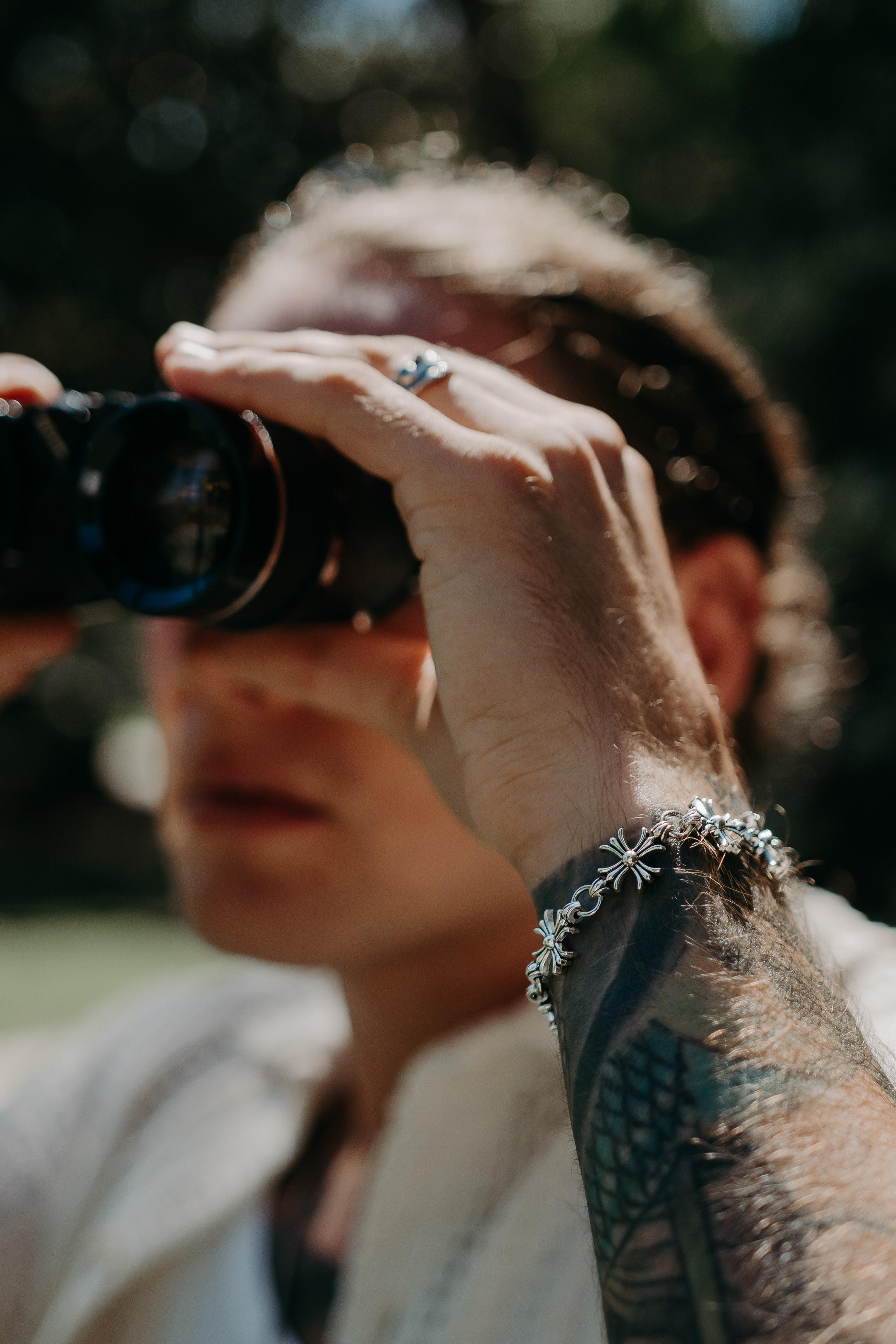 Close-up of a model with binoculars, blending outdoor adventure and modern style.