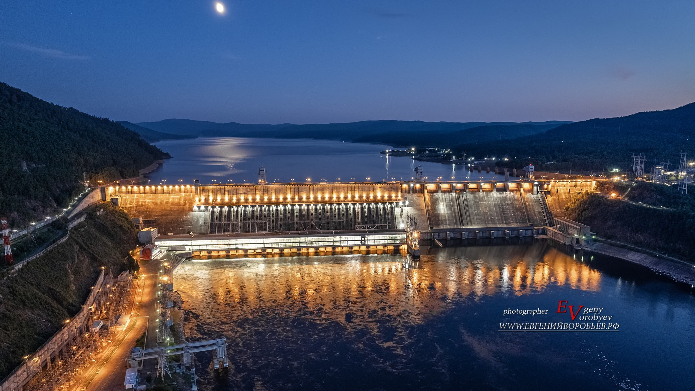 Плотина Красноярской ГЭС на реке Енисей с подсветкой Дивногорск аэросъёмка с дрона квадрокоптер фото репортаж профессиональный личный гид фотограф индивидуальная экскурсия Красноярск река Енисей коммунальный мост прогулка на теплоходе катере речной вокзал набережная исторический центр города путешествие достопримечательность что посмотреть где побывать в Сибири авторский фототур поездка на кабриолете заказать микроавтобус с водителем
