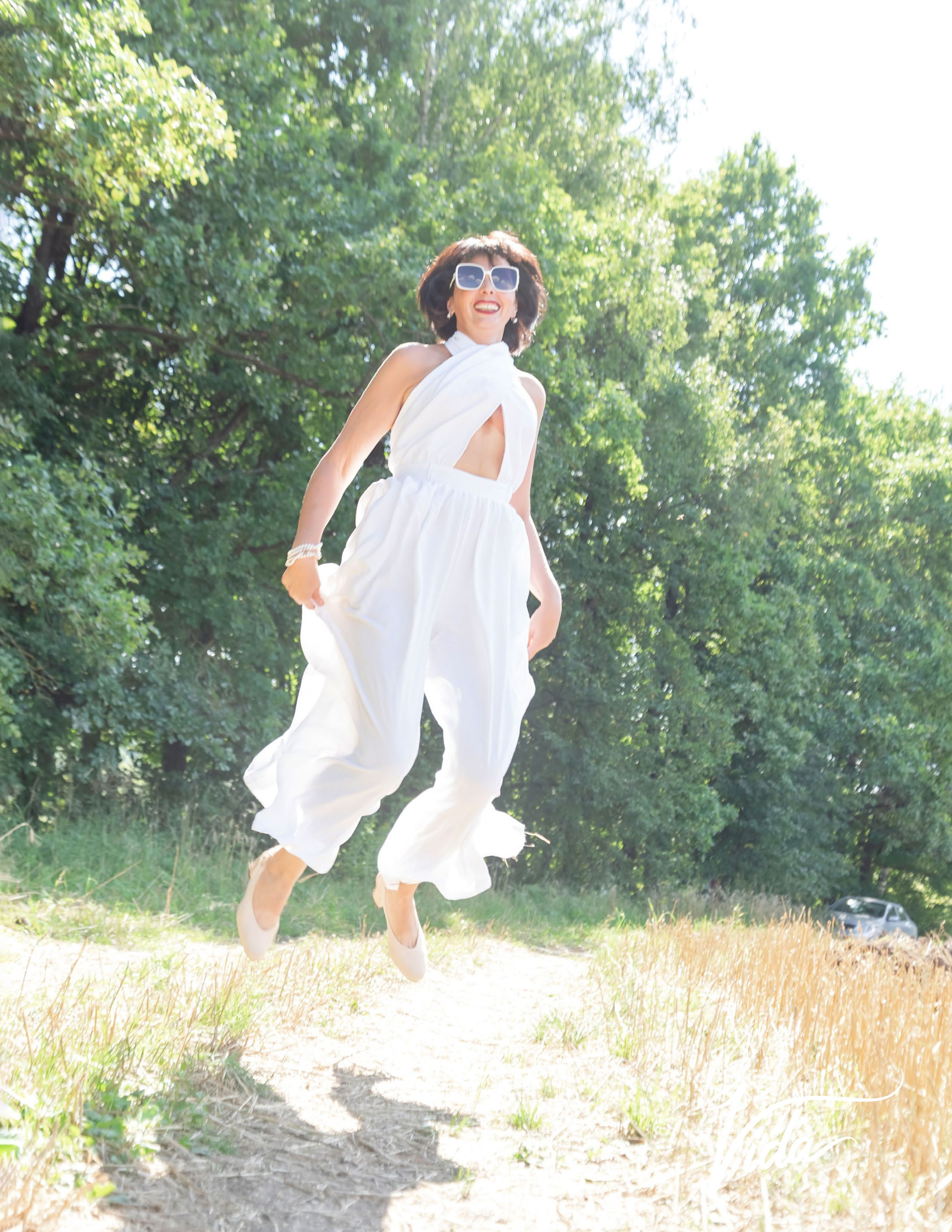 На фото отрывной лист журнала и девушка в белом комбинезоне в прыжке.