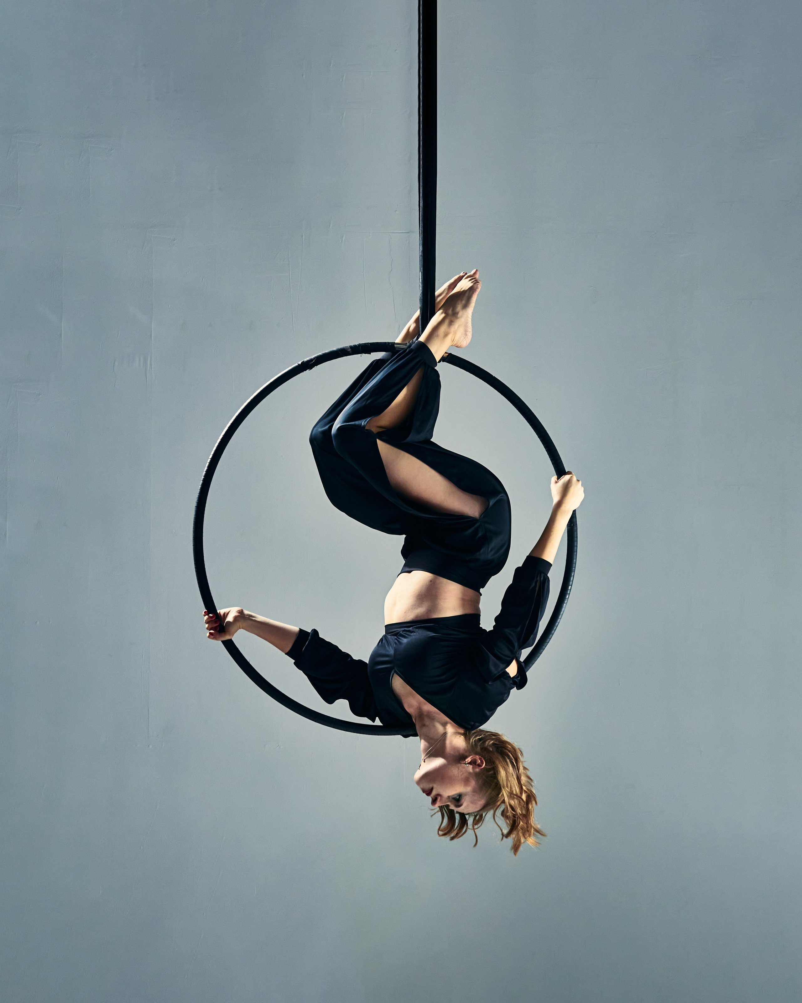 Творческий студийный портрет воздушной гимнастки на кольце в динамичной и выразительной позе | Профессиональная фотосессия для артистов, спортсменов и художественного портфолио
