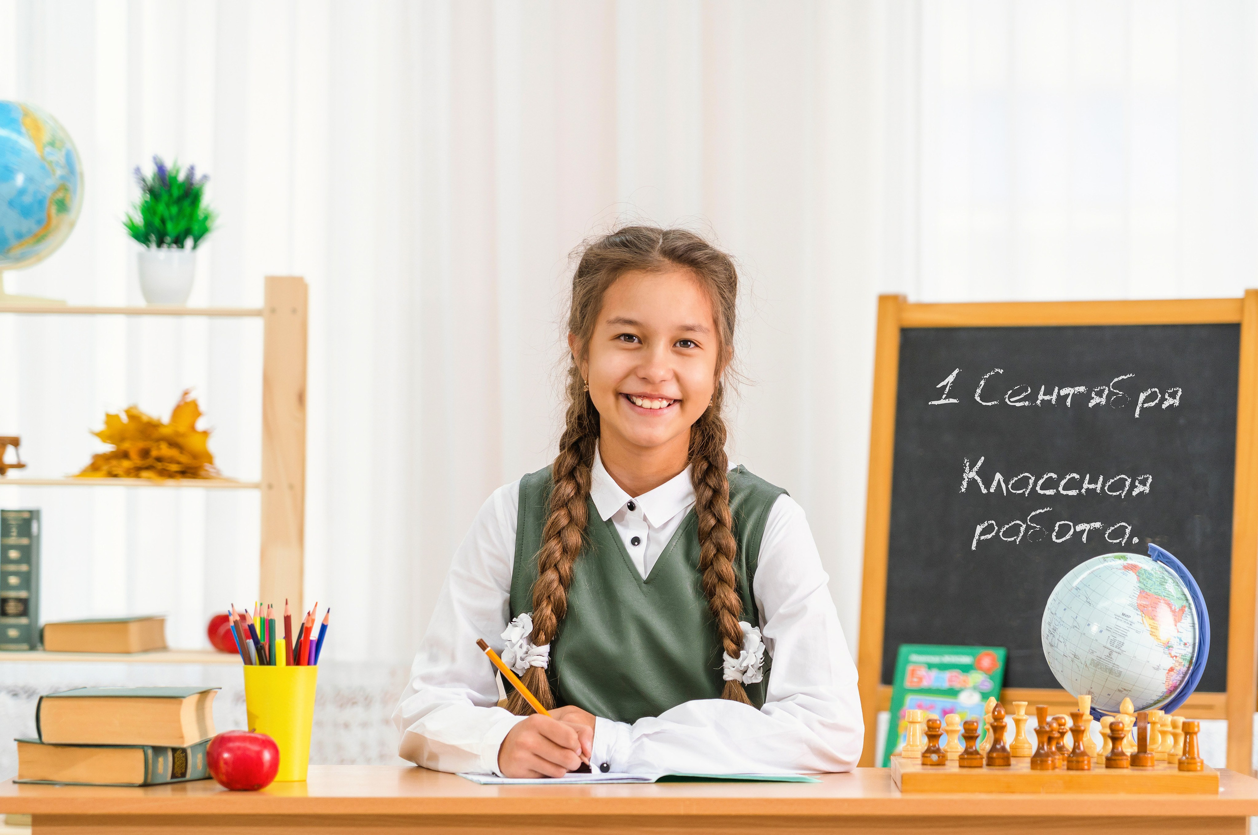 Школьница сидит за партой, школьный портрет