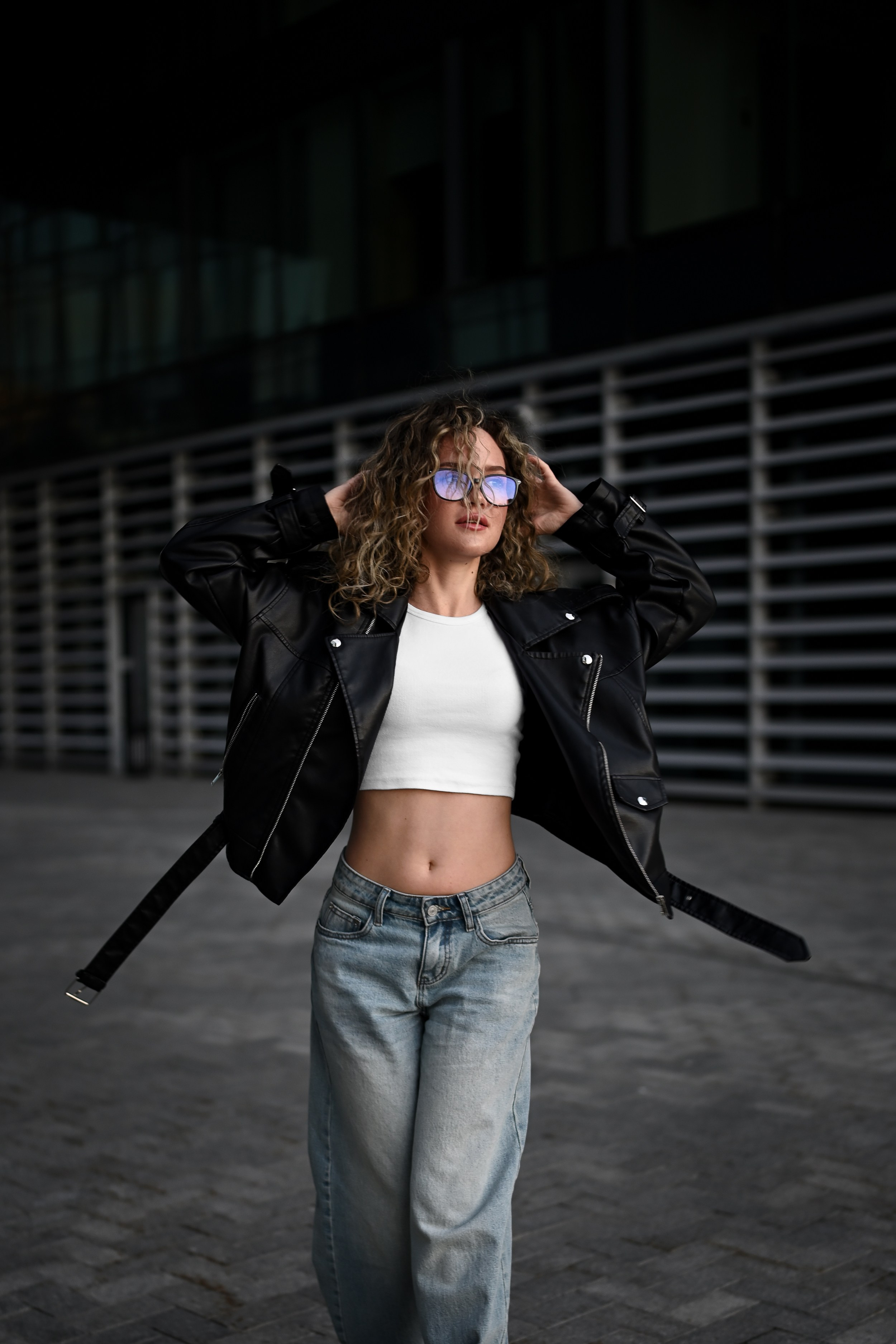 Уличный портрет девушки с кудрявыми волосами и очками в центре Казани на фоне городской архитектуры