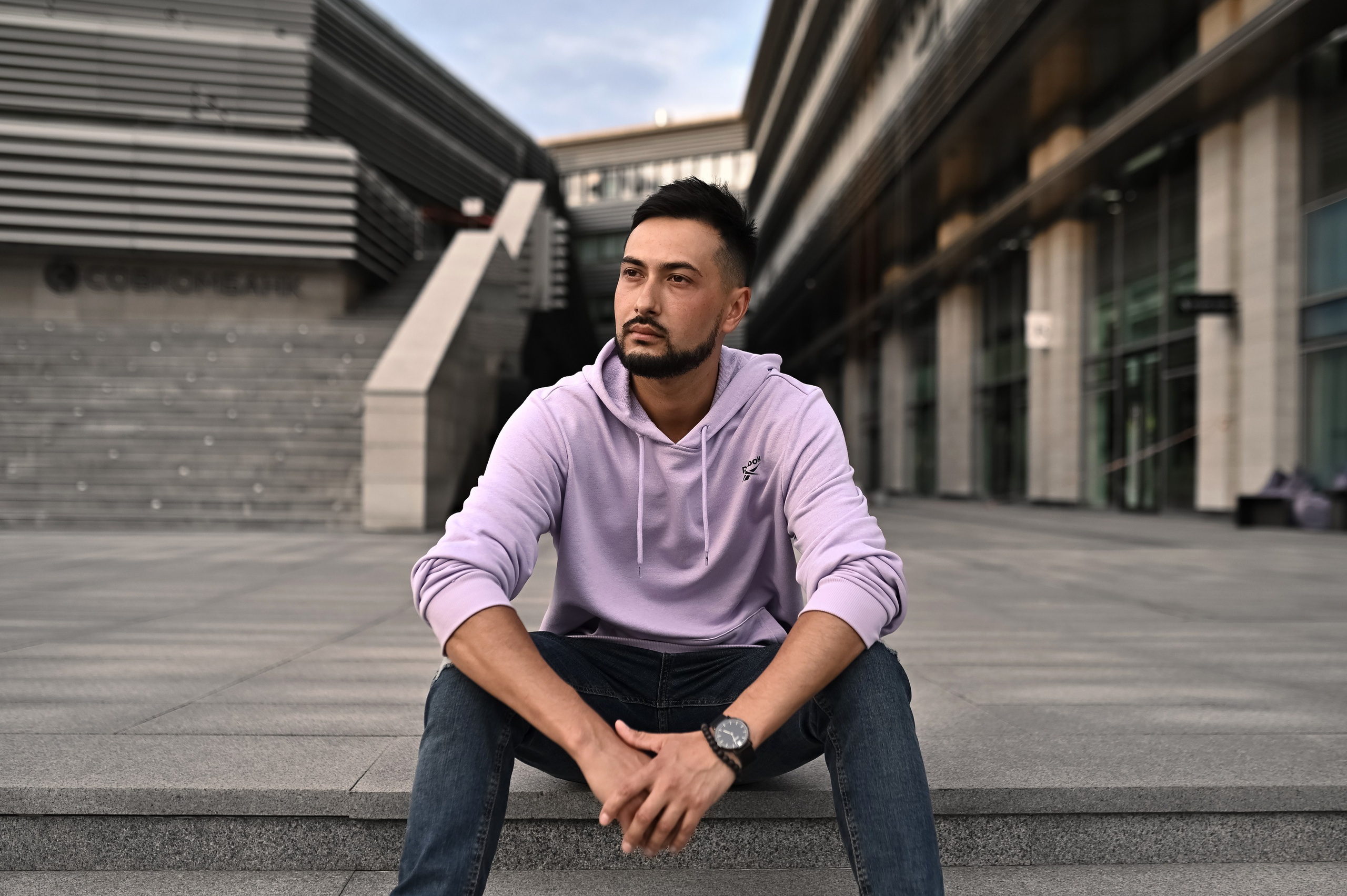 Уличная фотосессия мужчины в симметричной архитектура бизнес центра