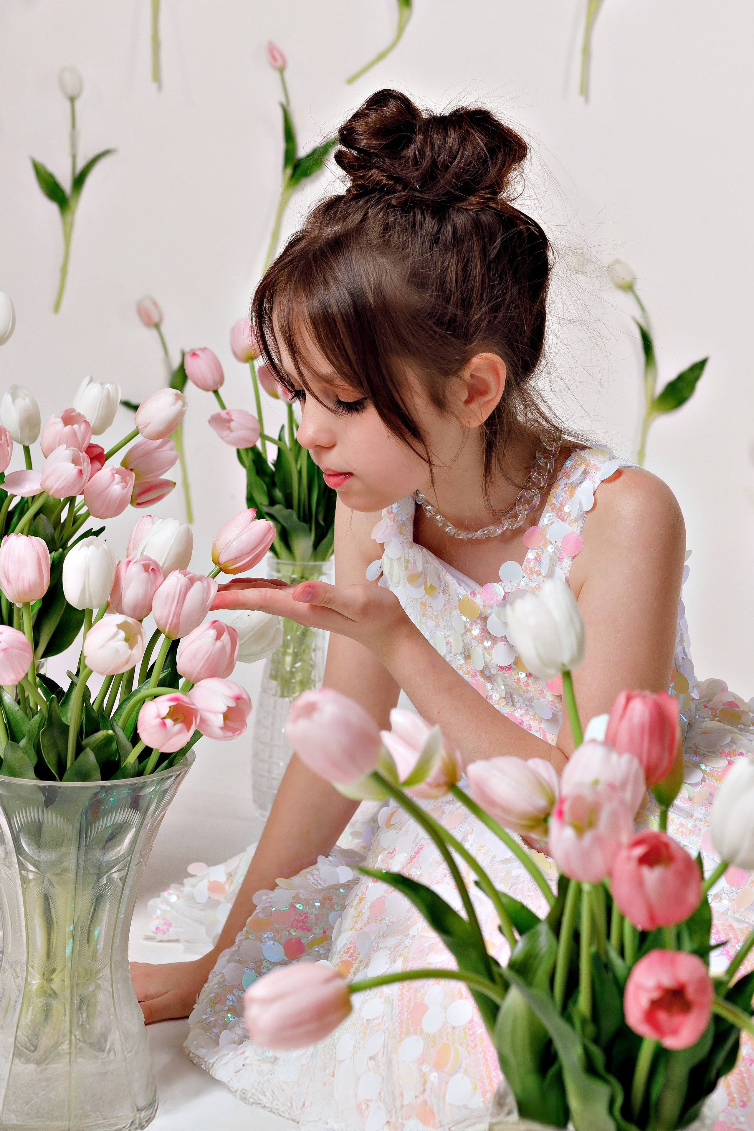 Именинница держит букет тюльпанов, сидя на украшенном стуле в фотостудии Сочи