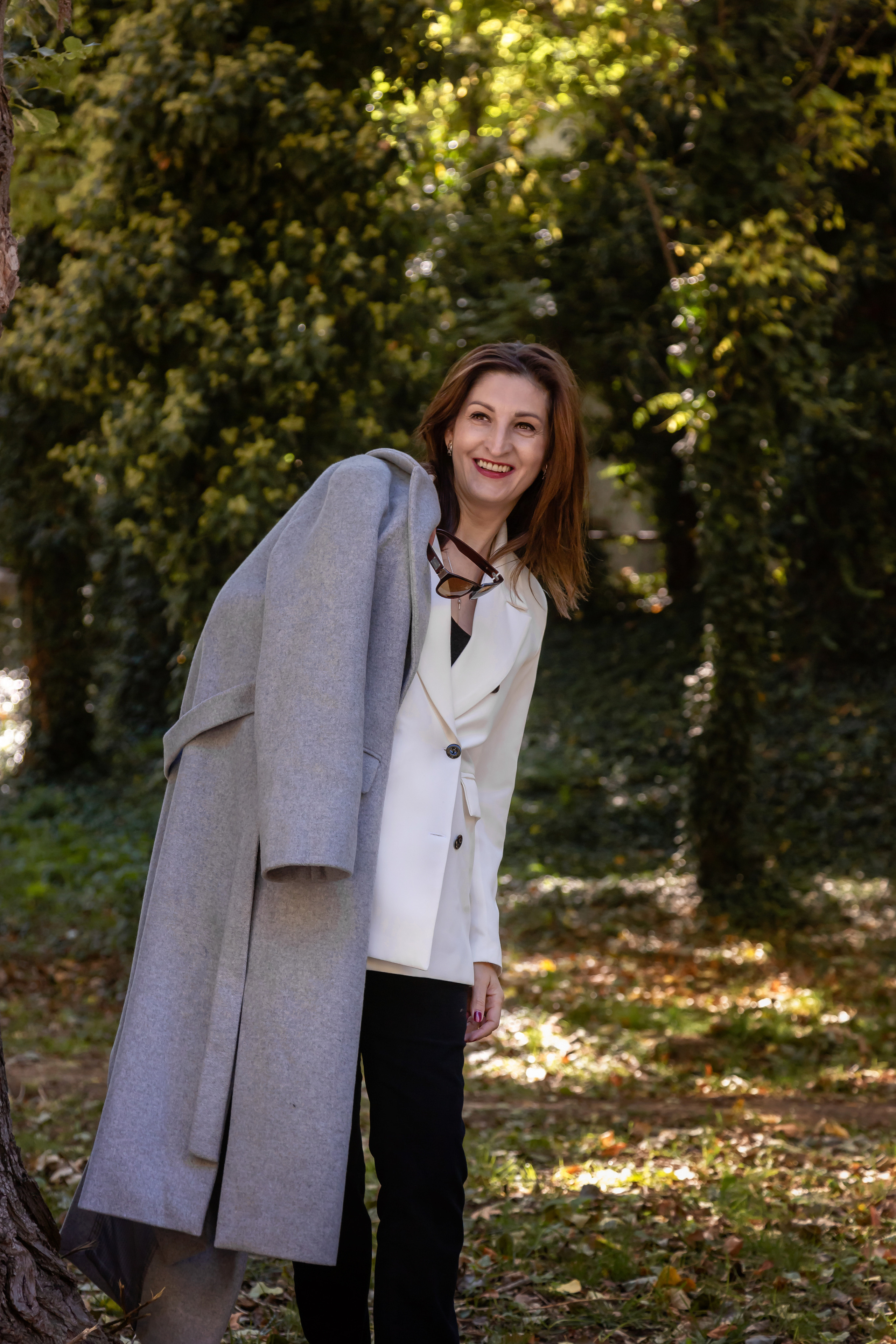 брюнетка с серым пальто на плече