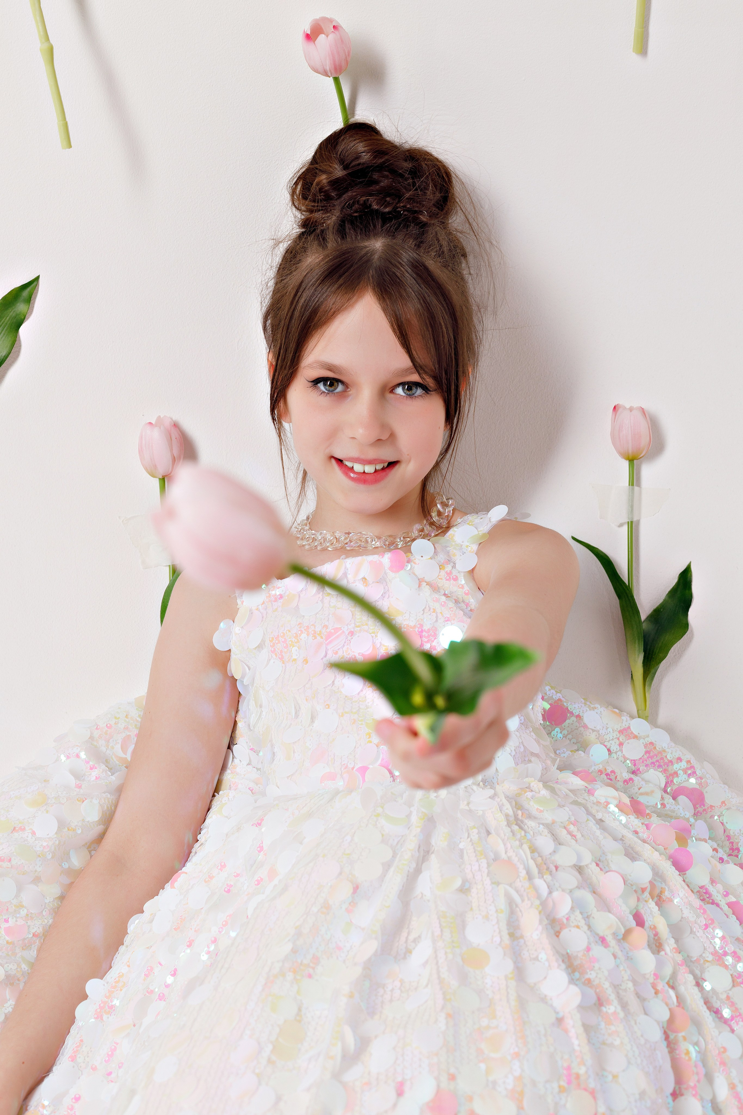 Портрет девочки с тюльпанами на фоне светлой фотозоны в Сочи
