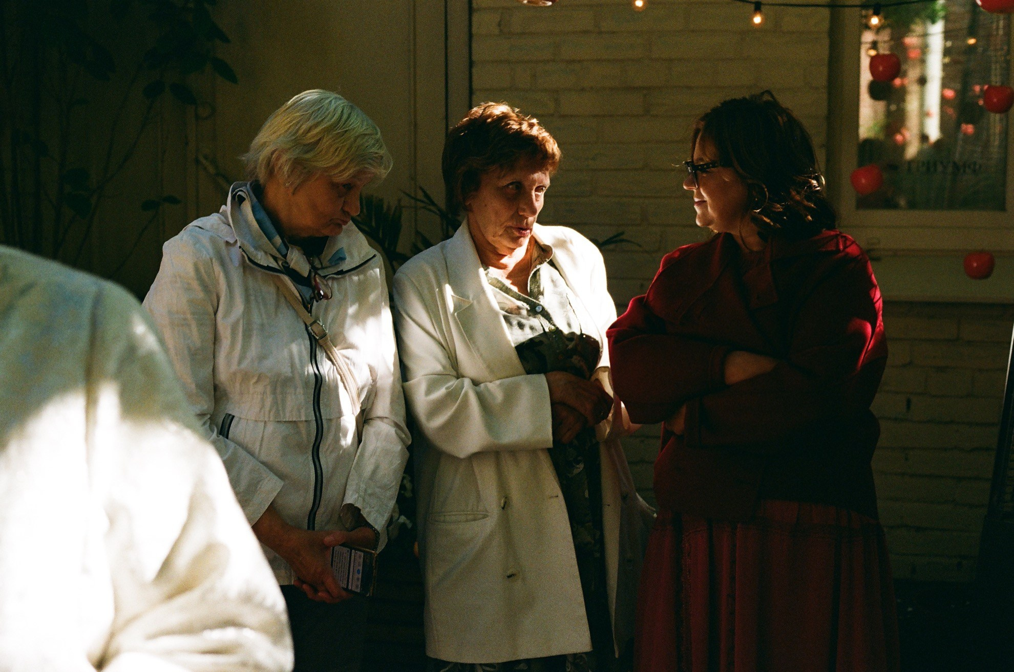 Старшие гости просматривают телефон в ожидании росписи, зернистый плёночный снимок