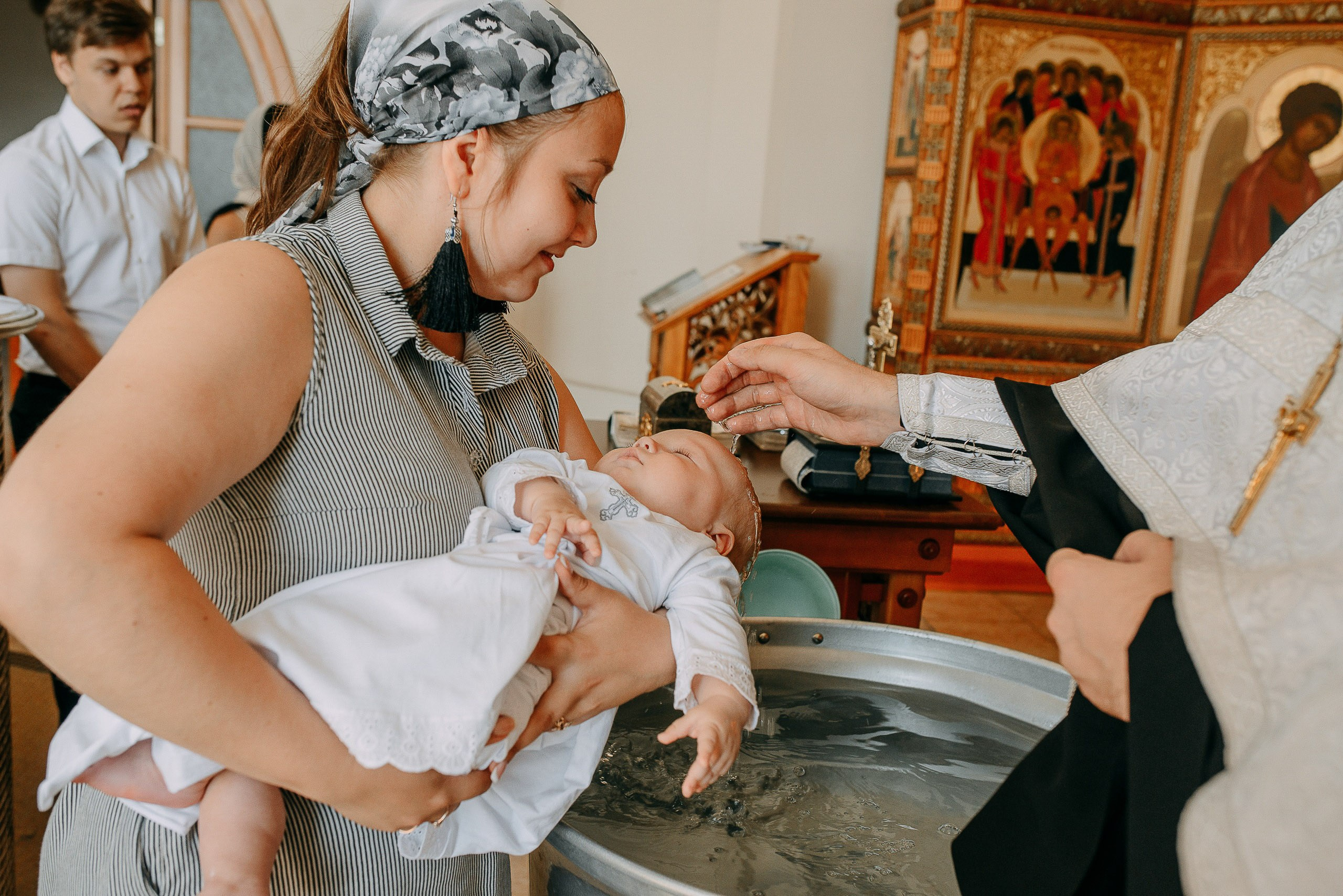 Православный фотограф в Новосибирске, запечатленный момент трехкратного обливания водой при крещении.