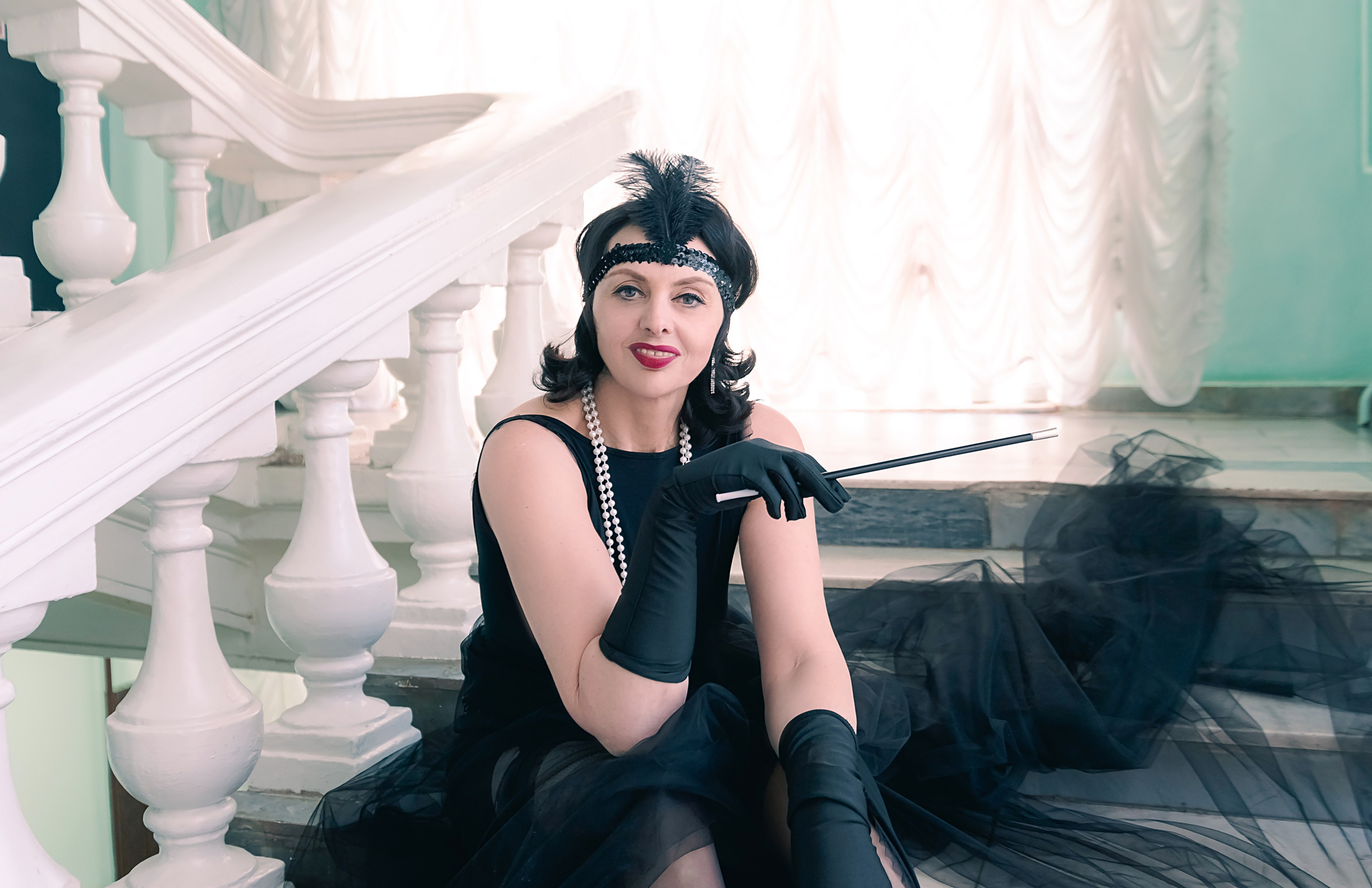 Девушка в стиле ретро, винтаж, Гэтсби на лестнице у окна.