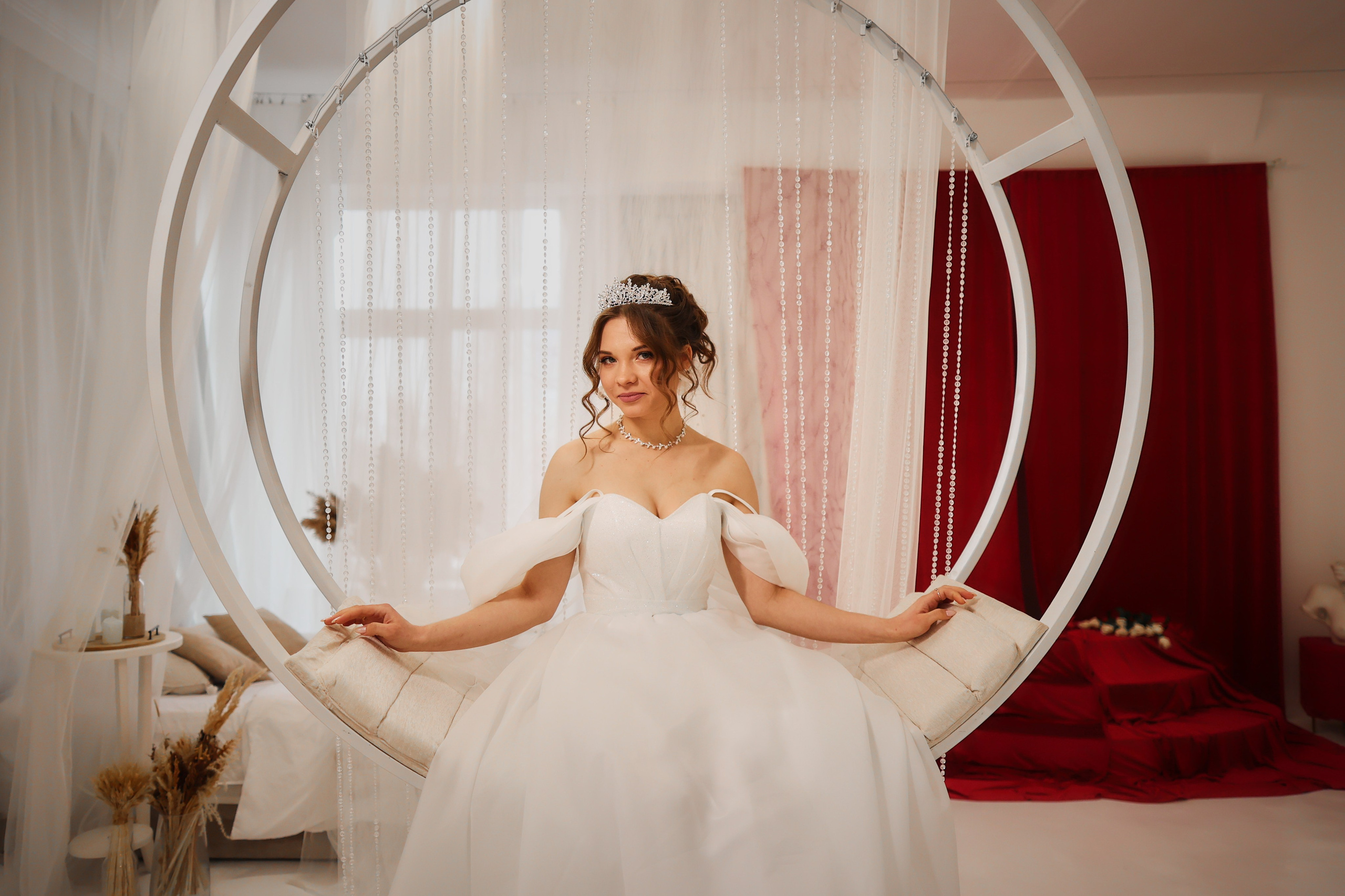 невеста в студии на красивых круглых белых качелях