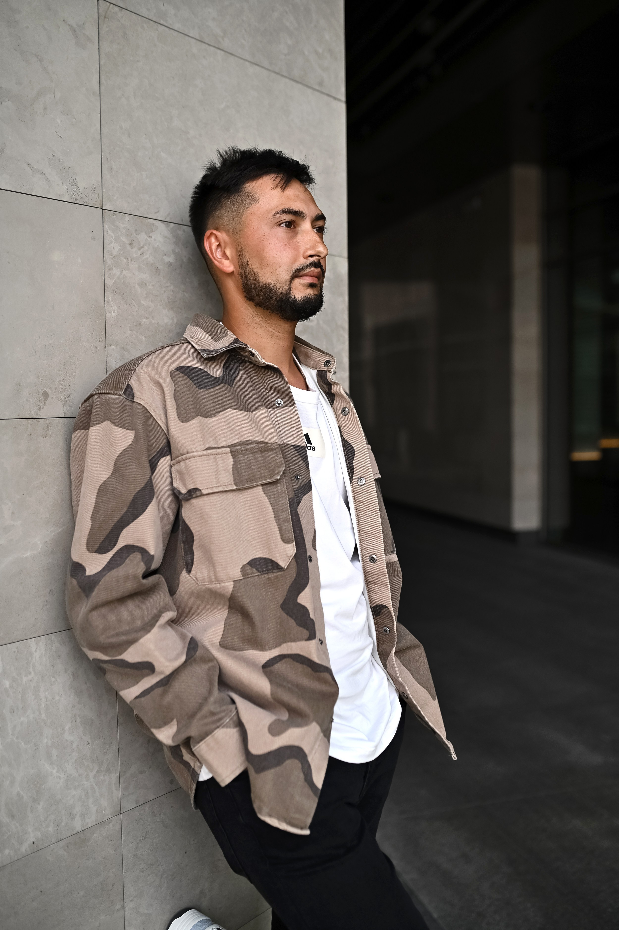 Мужчина позирует у архитектурной стены URBAN