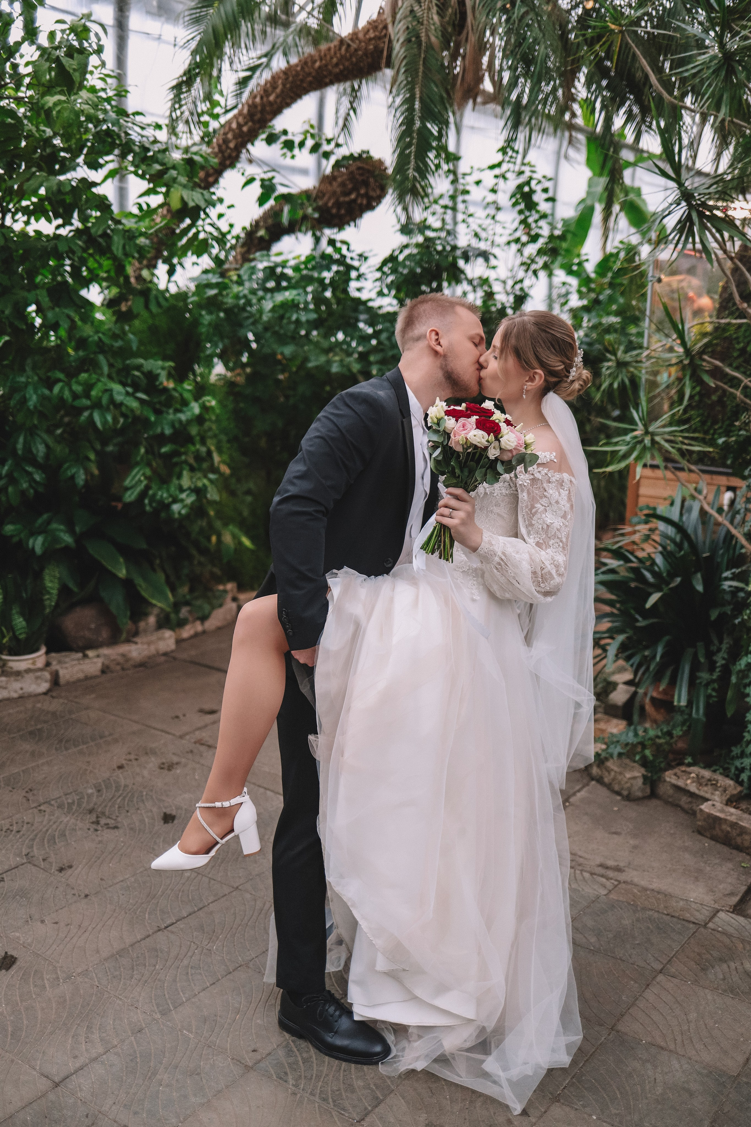 Жених целует невесту в оранжерее, свадебная фотосессия Санкт-Петербург