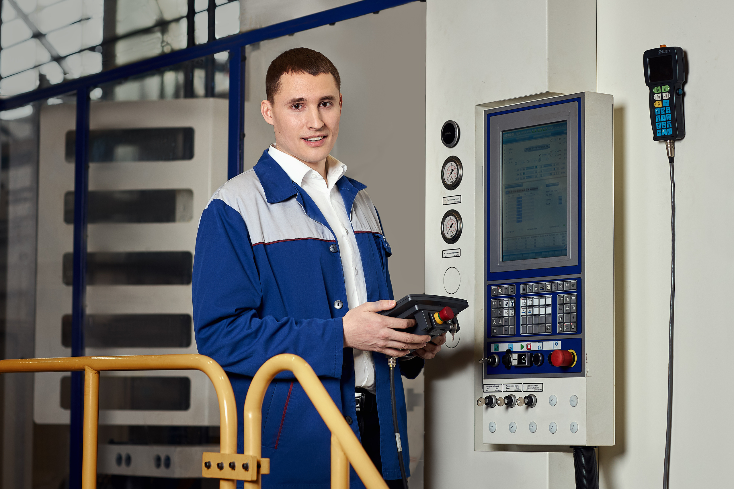 Инженер настраивает пульт управления станком.