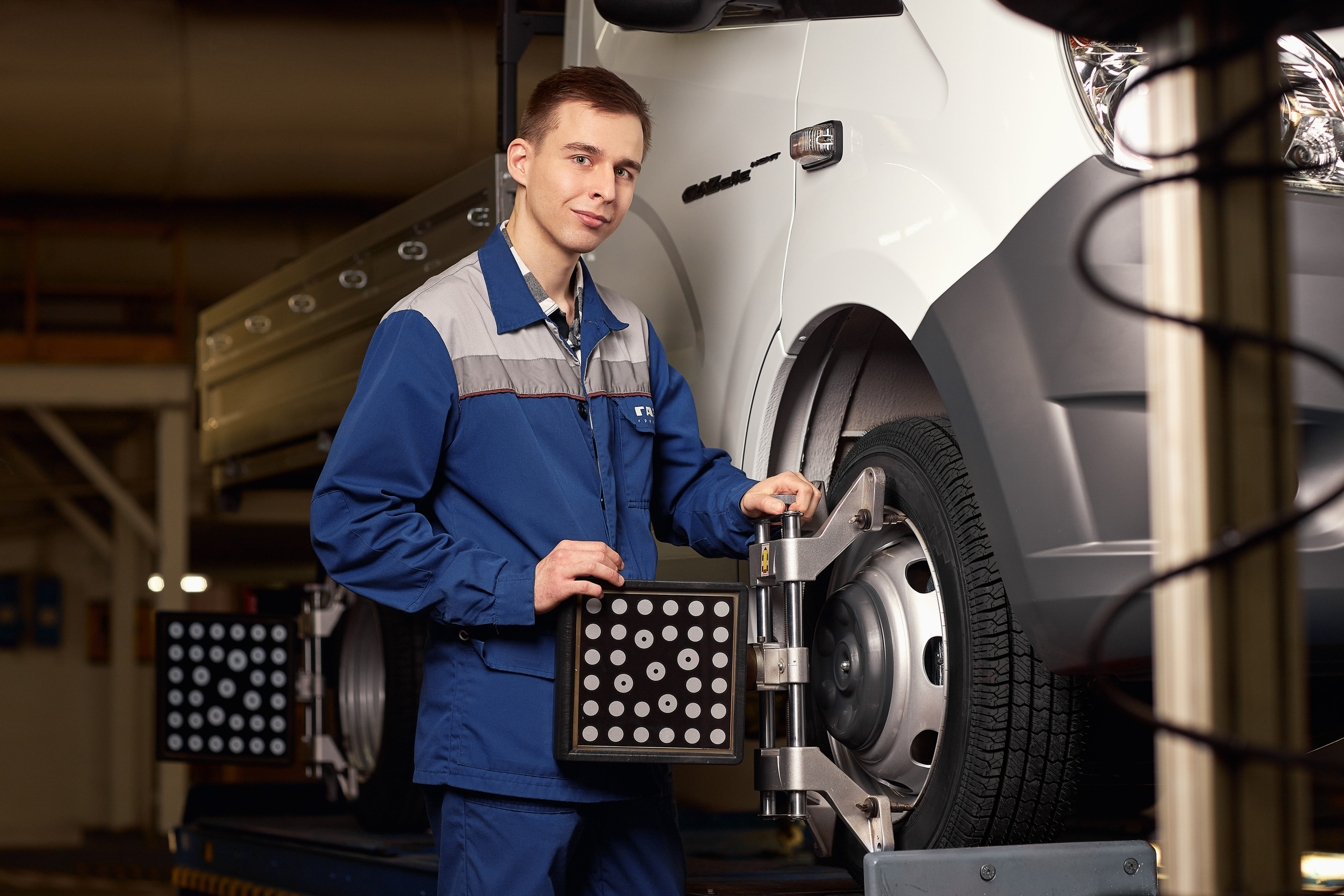 Рабочий настраивает баланс колёс автомобиля.