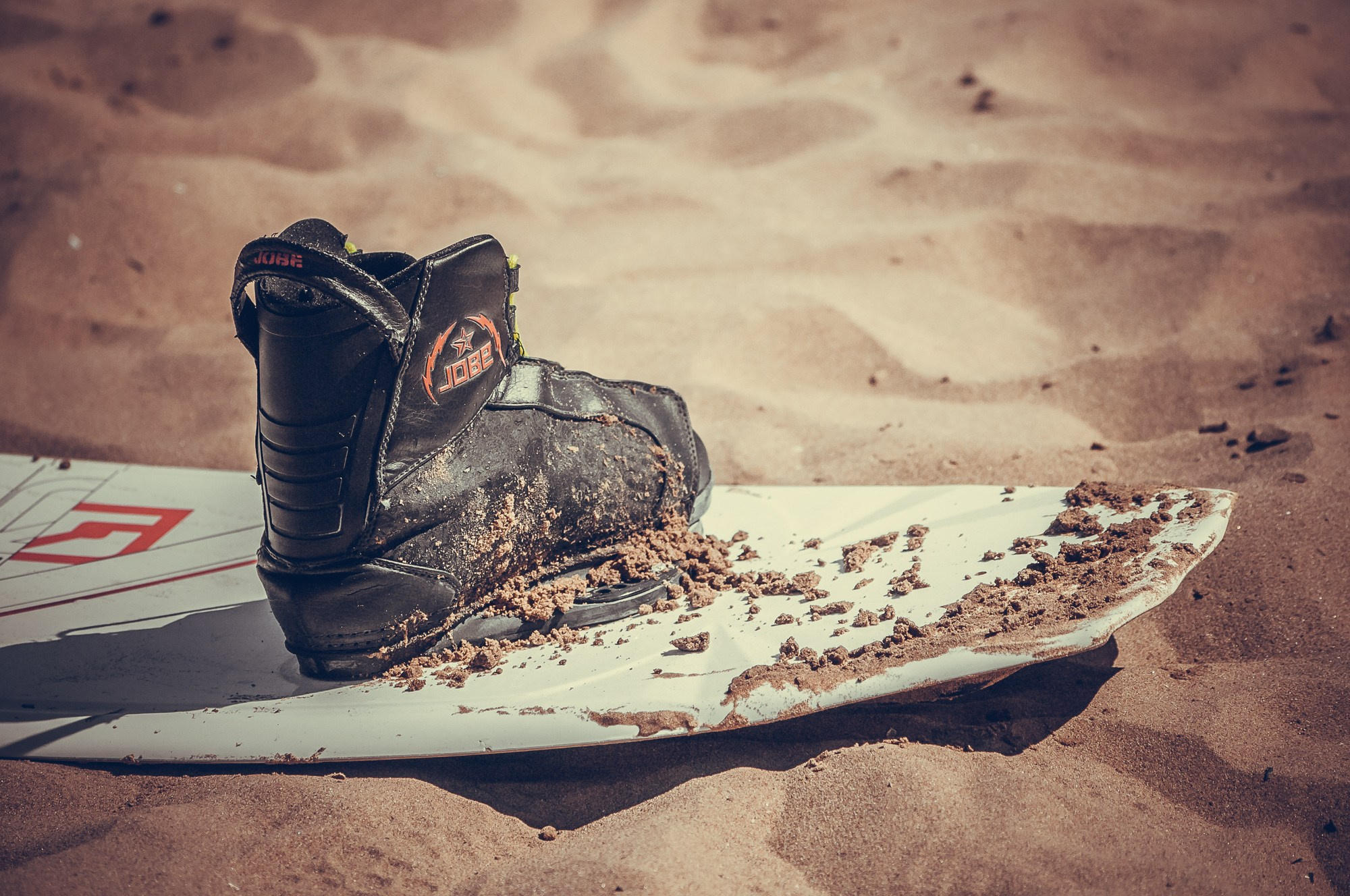 Ботинок и вейкборд на песчаном пляже