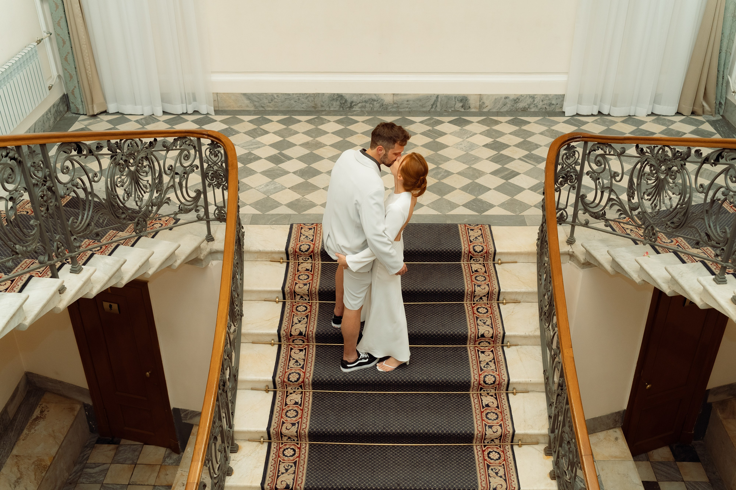 Молодожёны поднимаются по широкой мраморной лестнице, вид сверху, шаги в такт друг другу