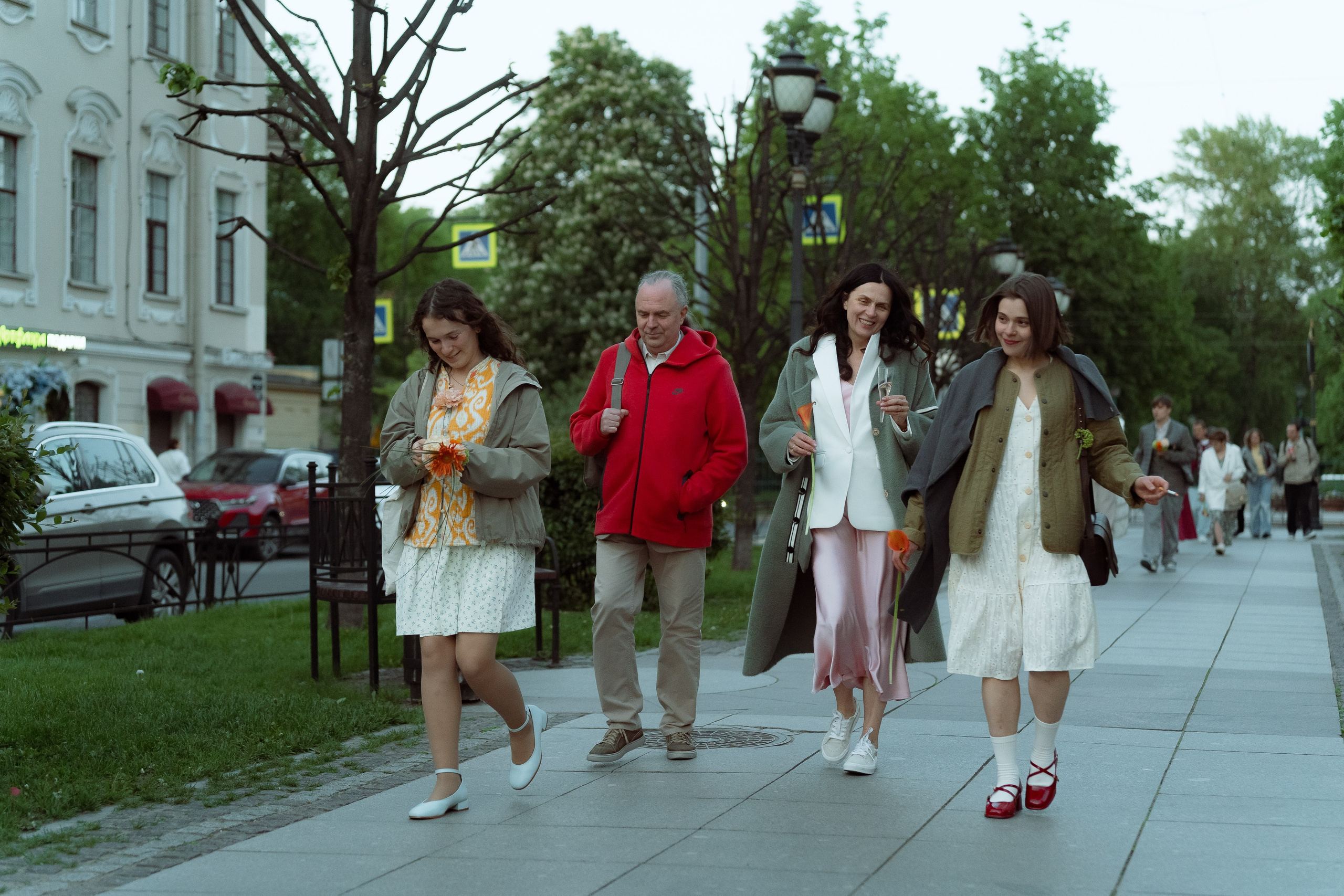 Мария и Евгений с букетом калл переходят широкую улицу Петербурга по пешеходному переходу