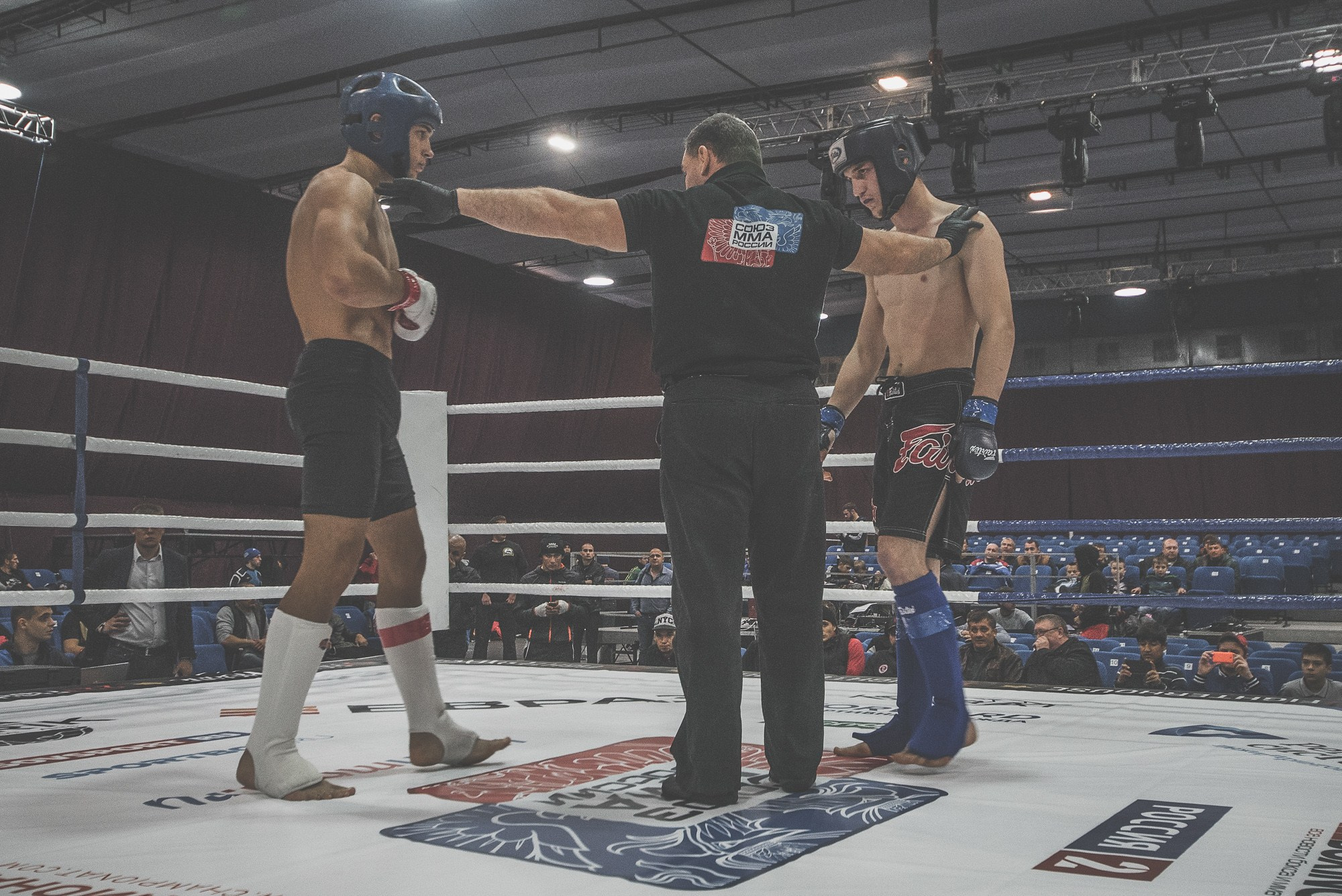 Судья соревнований разводит бойцов по углам, расставив руки в стороны