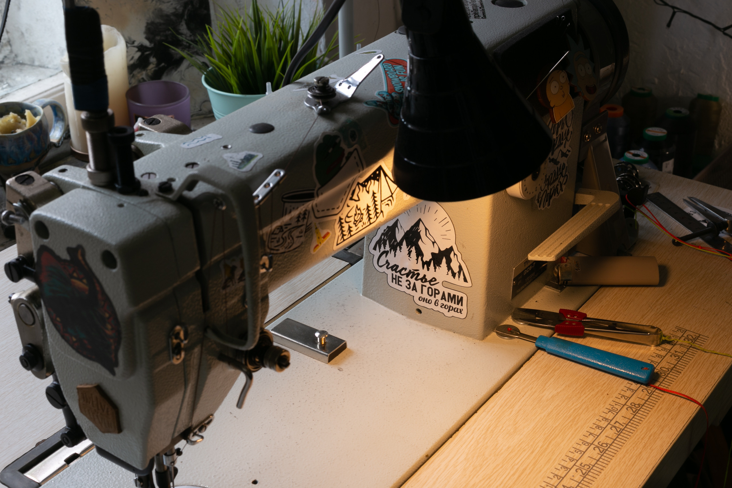 Теплый свет на фото. Швейная машинка, вид сверху. Наклейка Счастье не за горами, оно в горах.