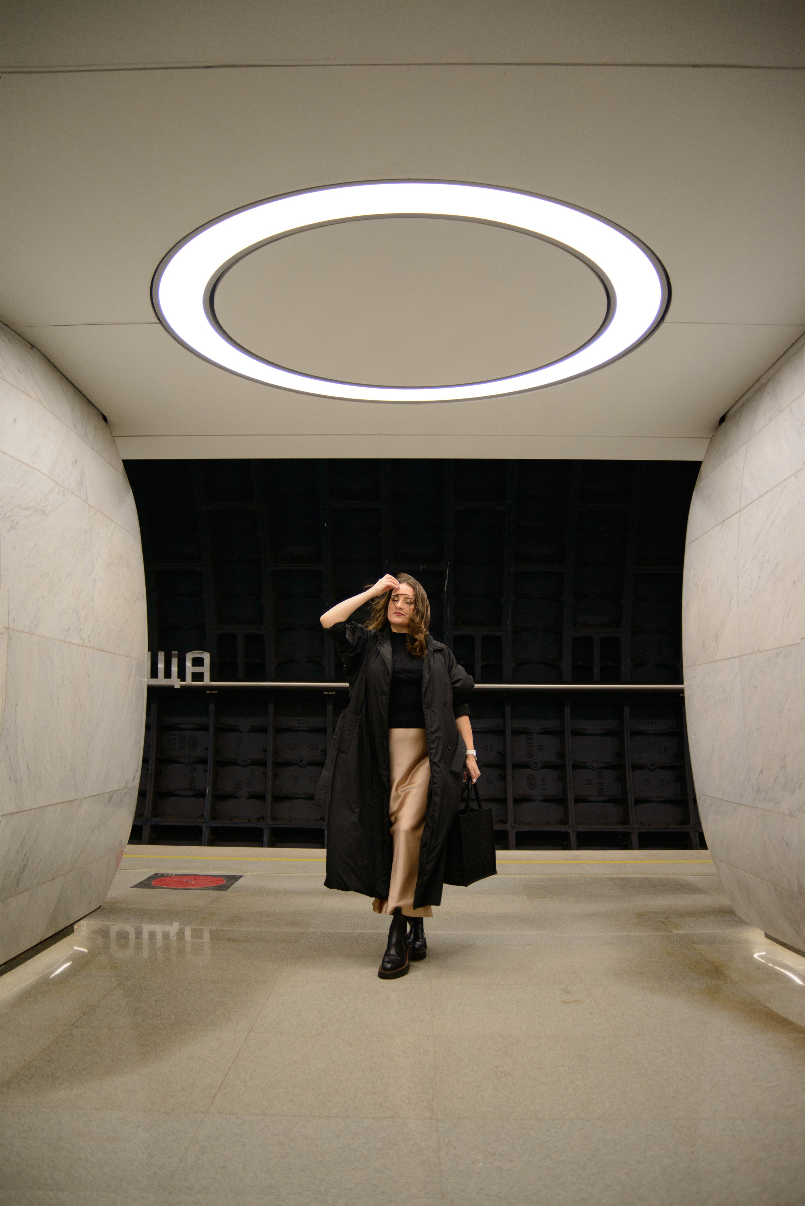 Девушка стоит на станции метро Рижская