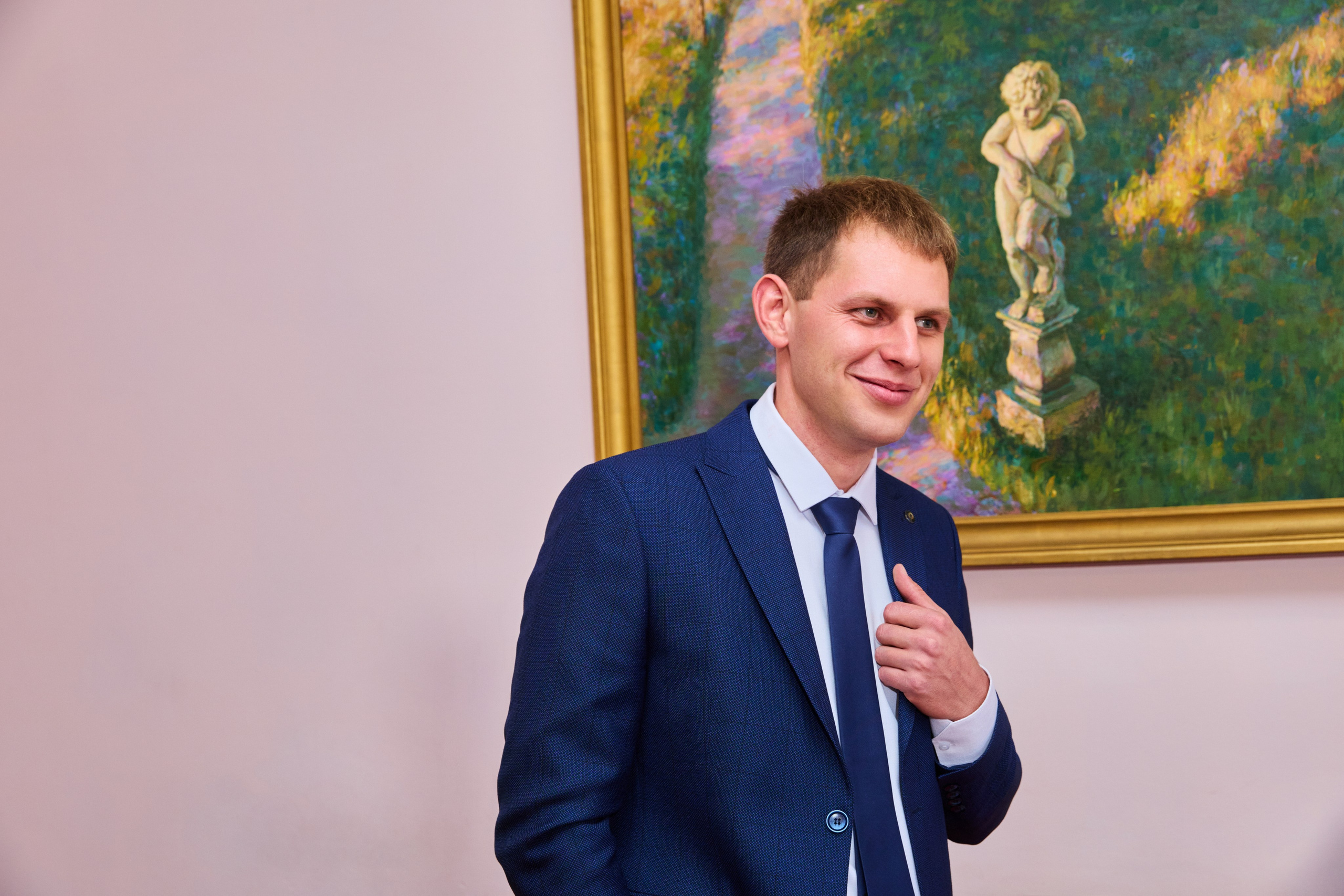 Жених улыбается на фоне картины