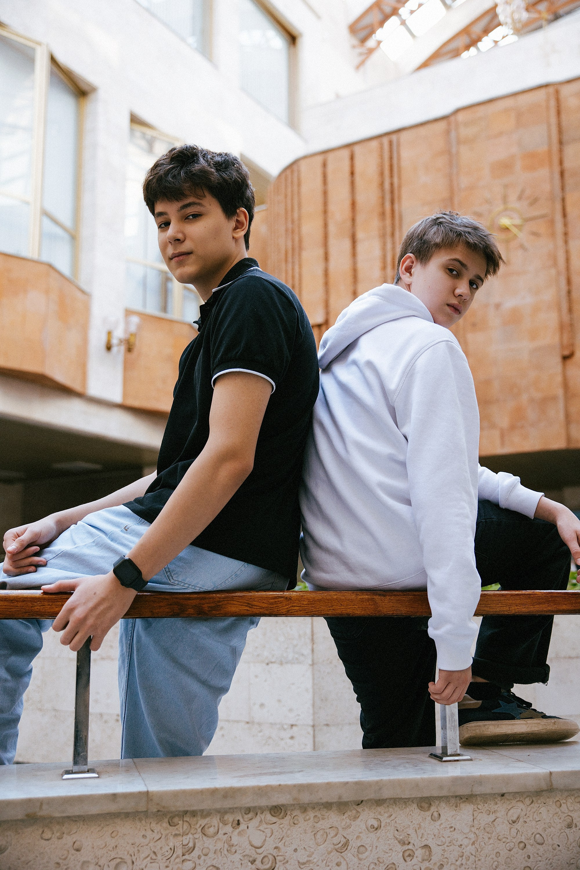 Два выпускника в стиле кэжуал позируют для фотосессии в Доме профсоюзов, архитектура советского модернизма, фотографии для выпускного альбома.