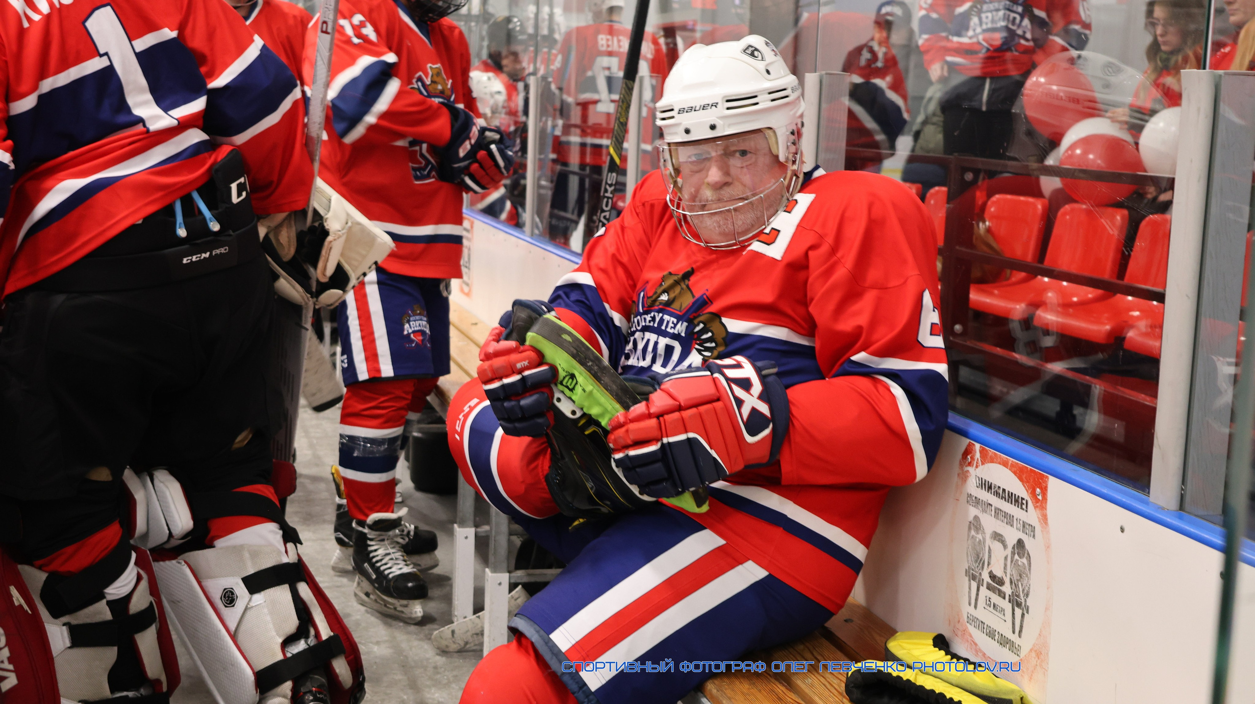 Хоккеист растягивает ногу на скамье запасных