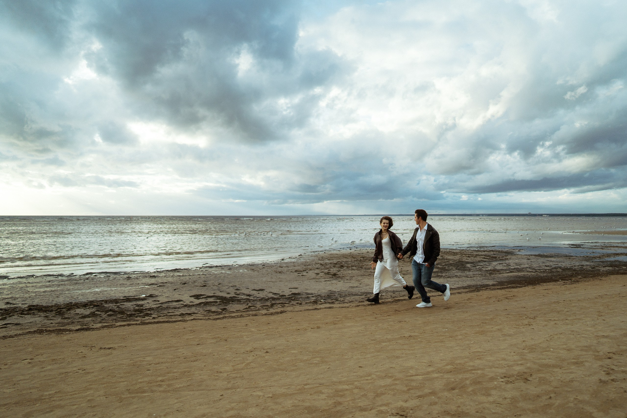 Пара идёт вдоль берега — прогулка по пляжу у Финского залива, свадебная съёмка