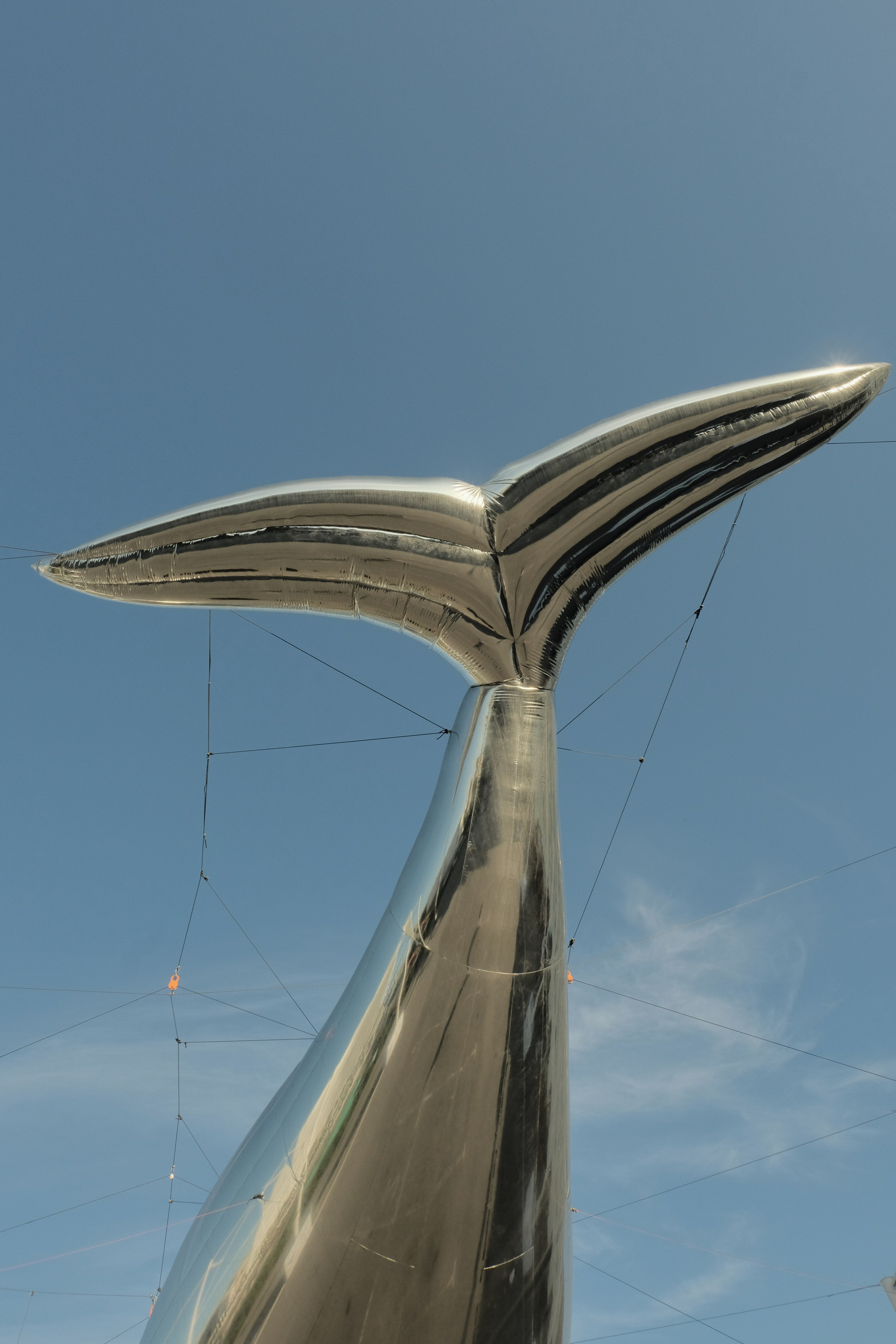 whale tail sculpture against clear blue sky, outdoor art installation in Teriberka, Murmansk