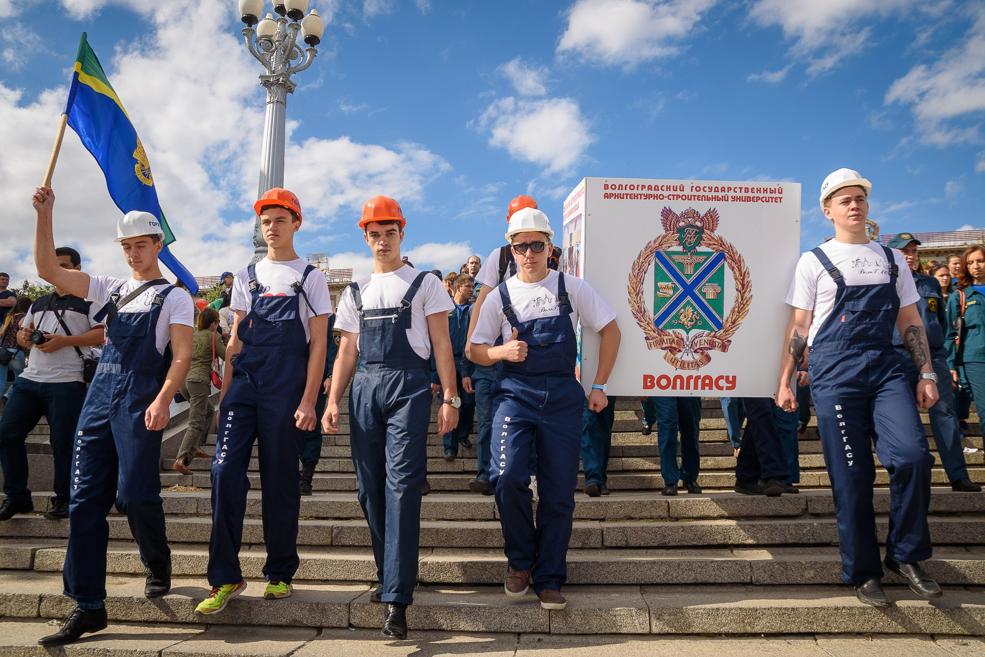 Студенты идут с транспарантом по ступеням набережной Волгограда