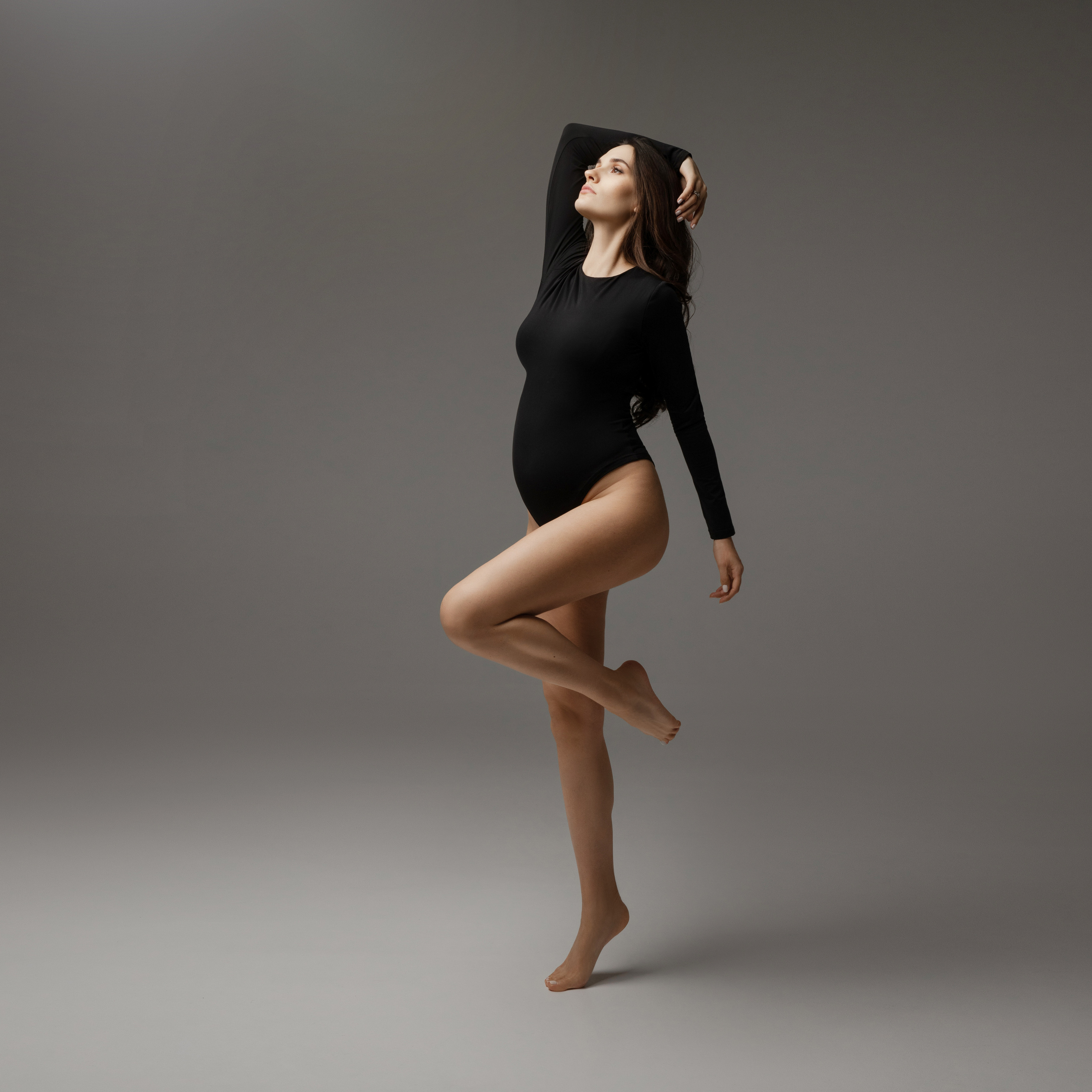 Фотосессия беременных в черных боди, подчеркивающих беременный живот.