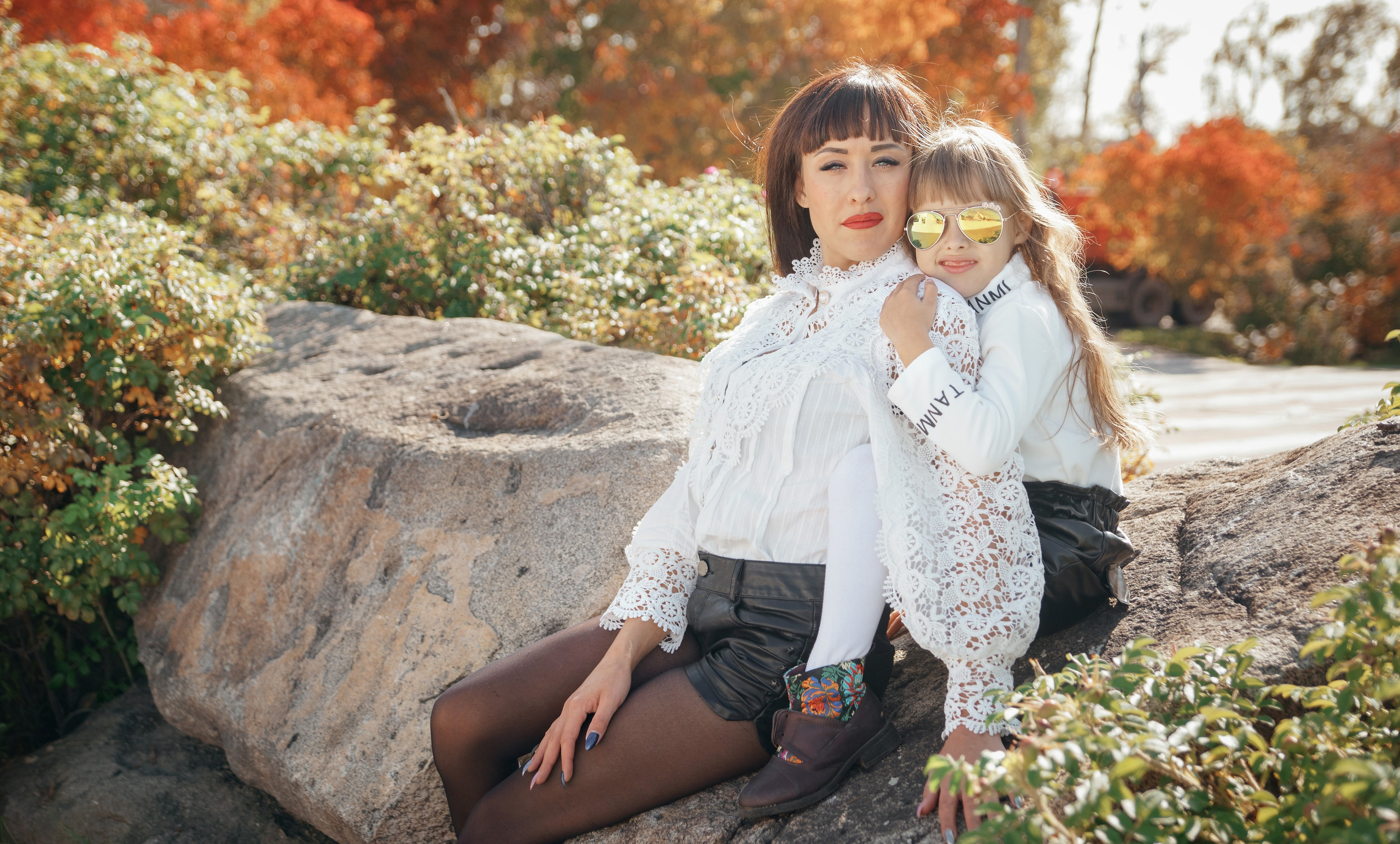 Семейная осенняя фотосессия в парке - мама с дочкой сидя на камне