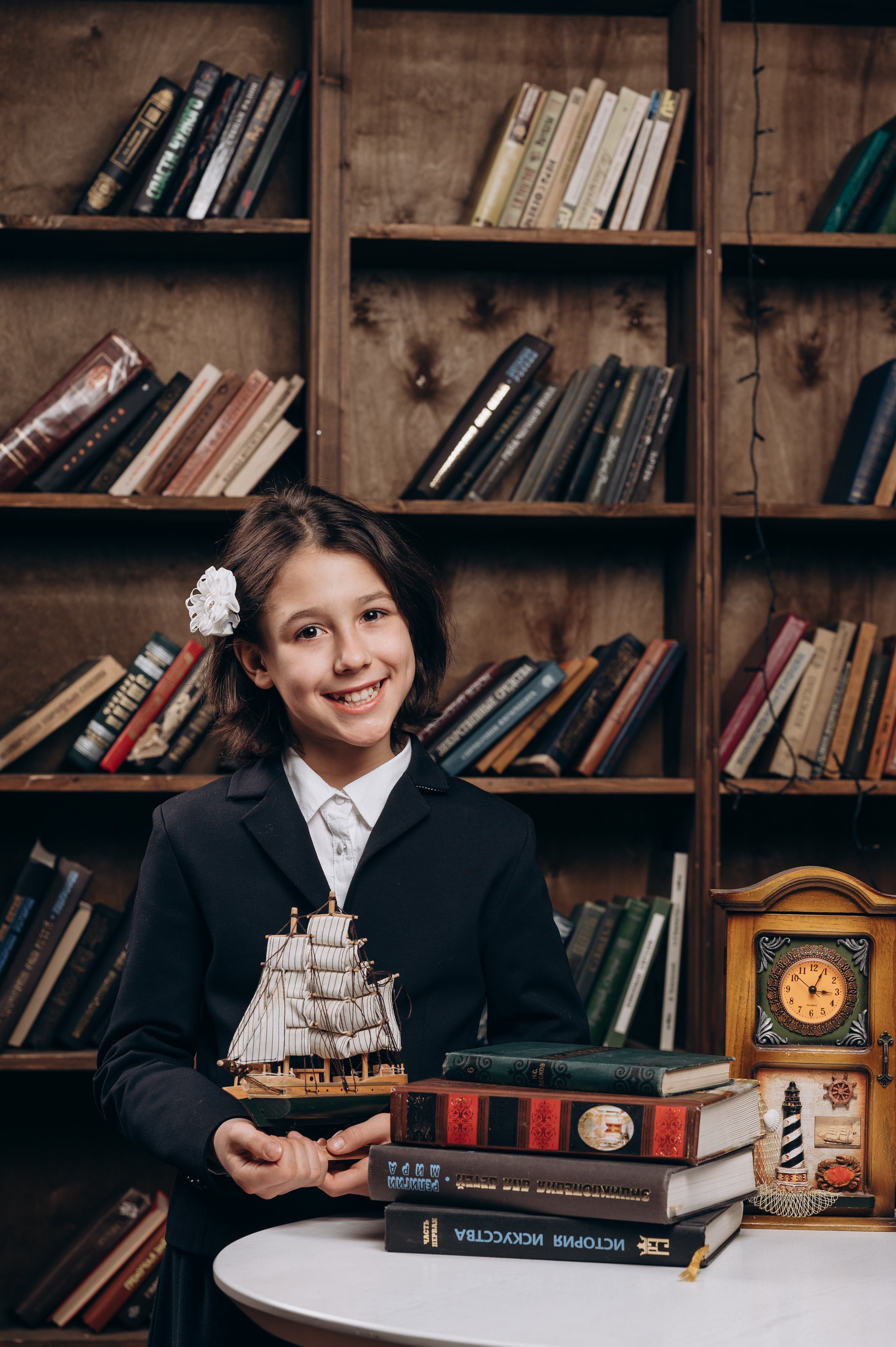 выпускница 4 класса на фоне книжных полок