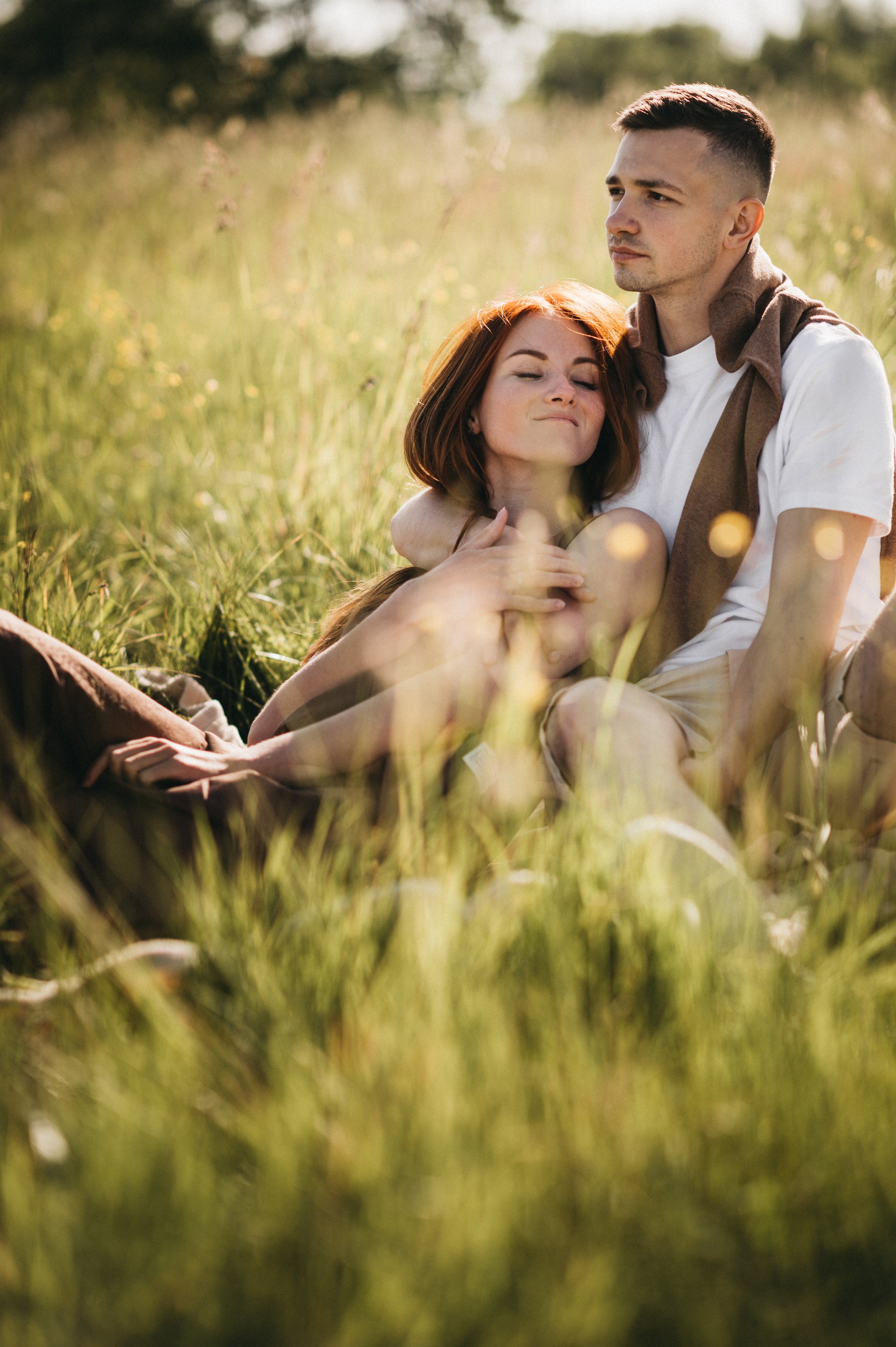 Пара сидит на траве во время отдыха на природе